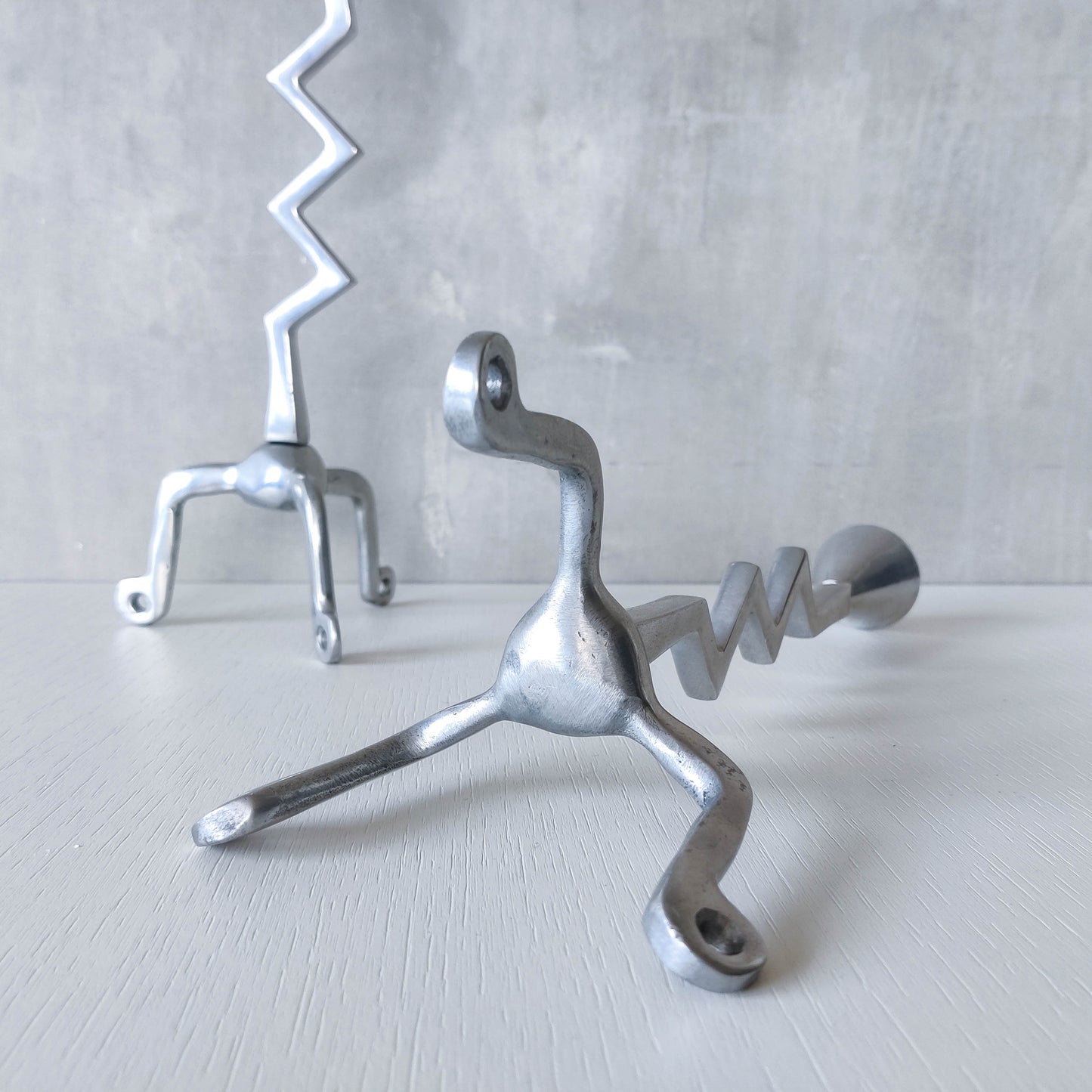 Pair of vintage postmodern chunky sculptural zigzag cast aluminium footed candle holders