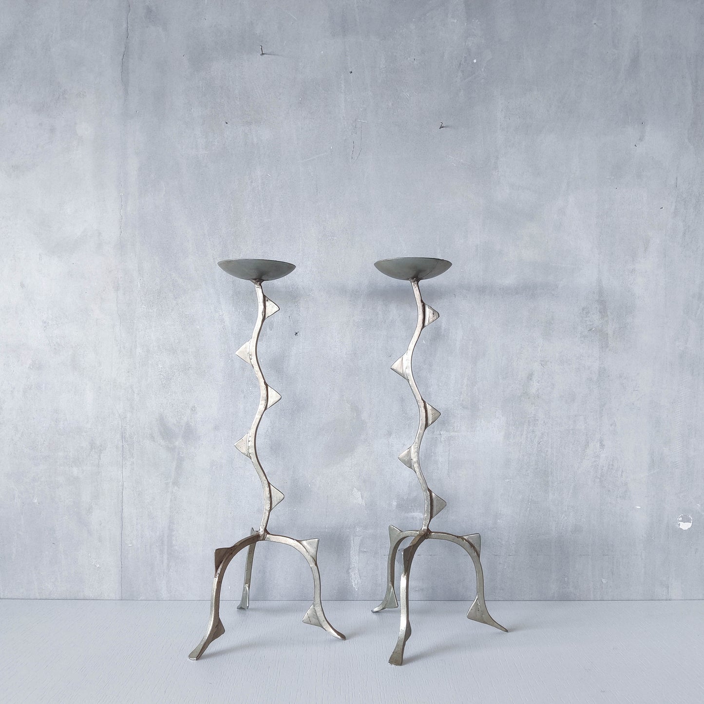 Pair of tall vintage sculptural wavy zigzag footed aluminium candle holders