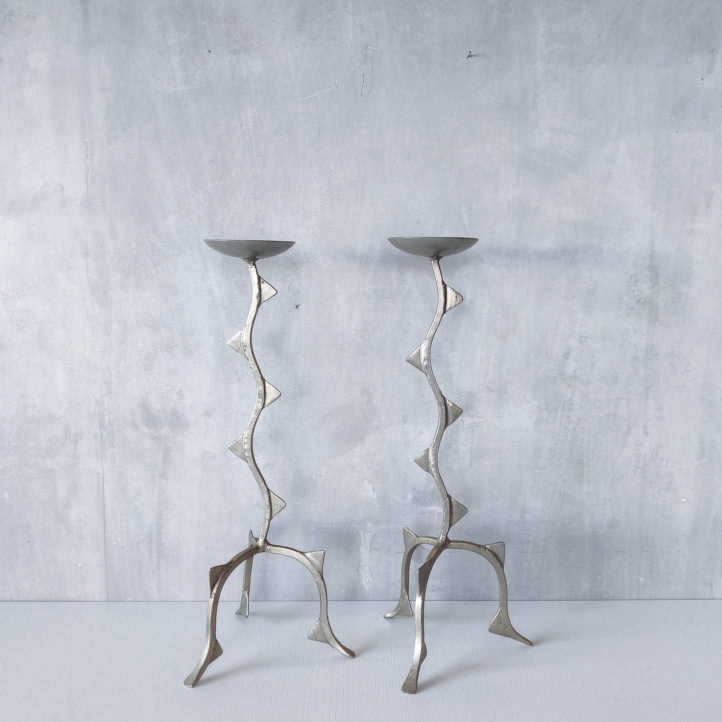 Pair of tall vintage sculptural wavy zigzag footed aluminium candle holders