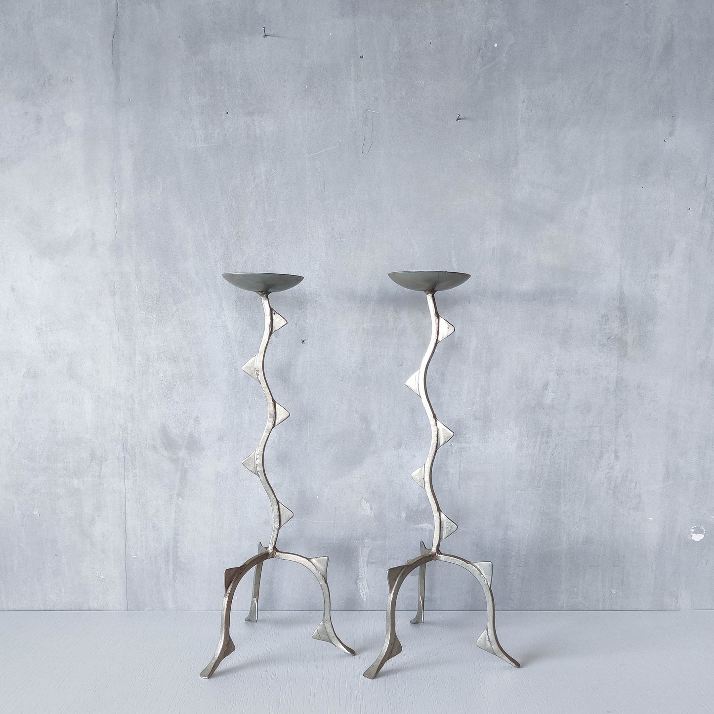 Pair of tall vintage sculptural wavy zigzag footed aluminium candle holders