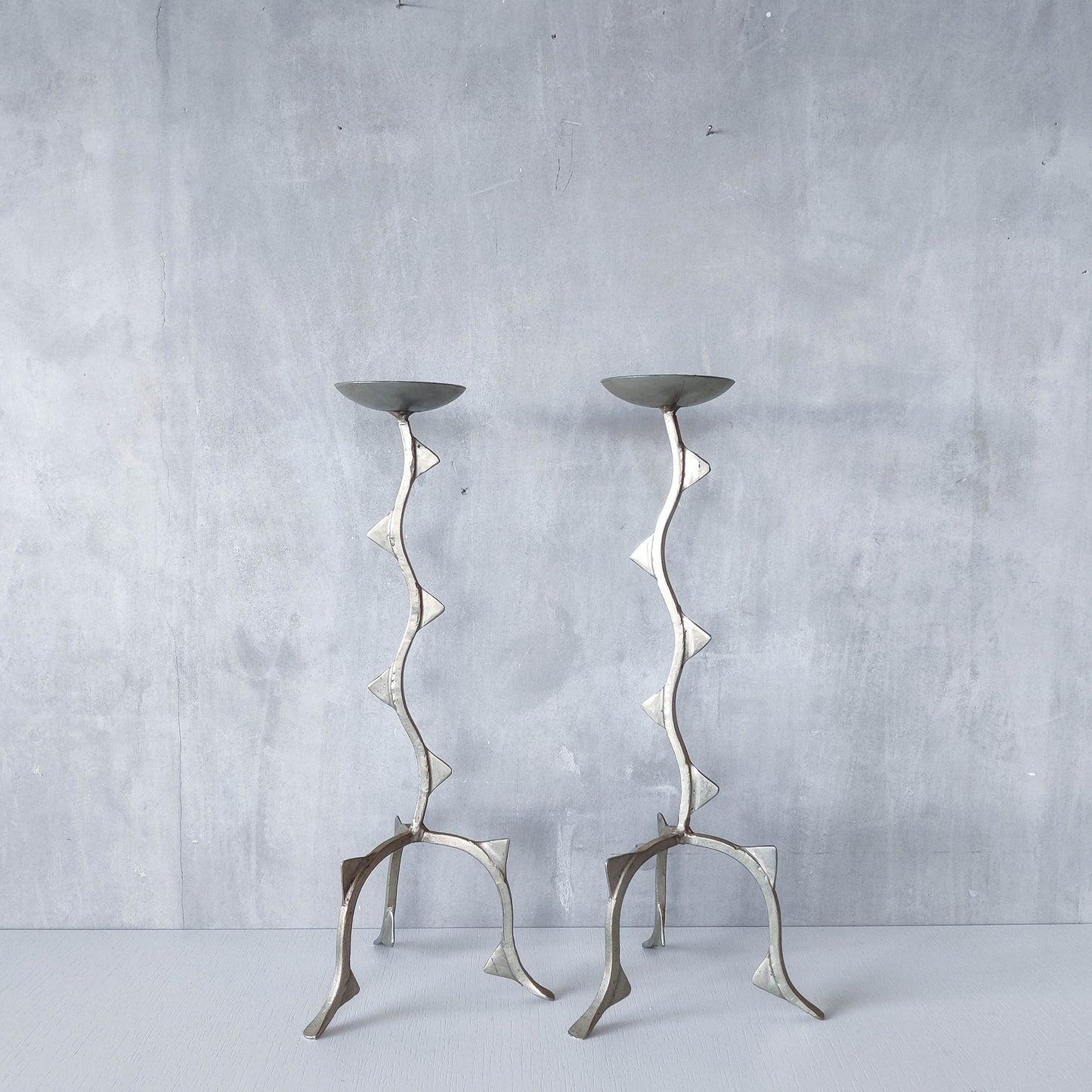 Pair of tall vintage sculptural wavy zigzag footed aluminium candle holders