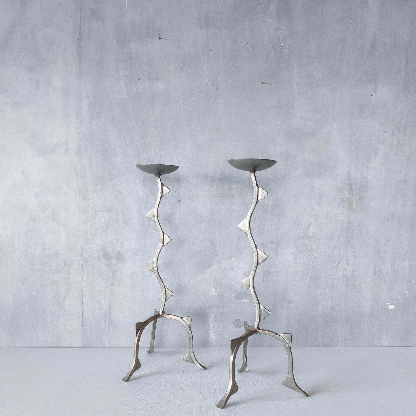 Pair of tall vintage sculptural wavy zigzag footed aluminium candle holders