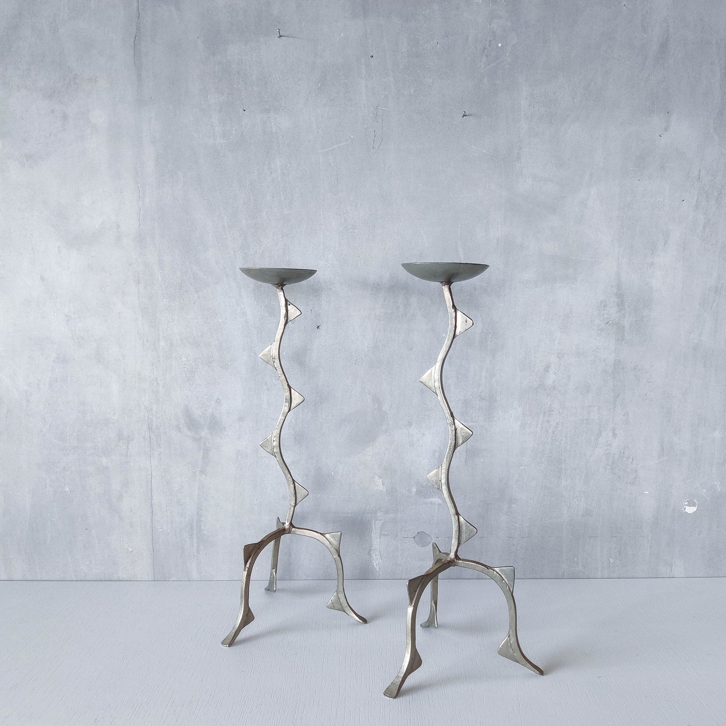 Pair of tall vintage sculptural wavy zigzag footed aluminium candle holders