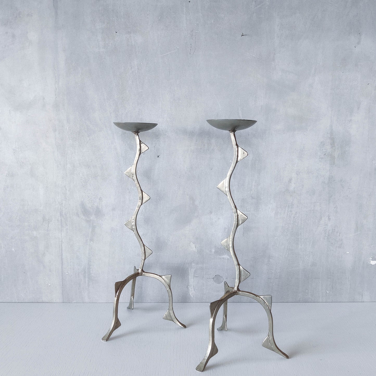 Pair of tall vintage sculptural wavy zigzag footed aluminium candle holders