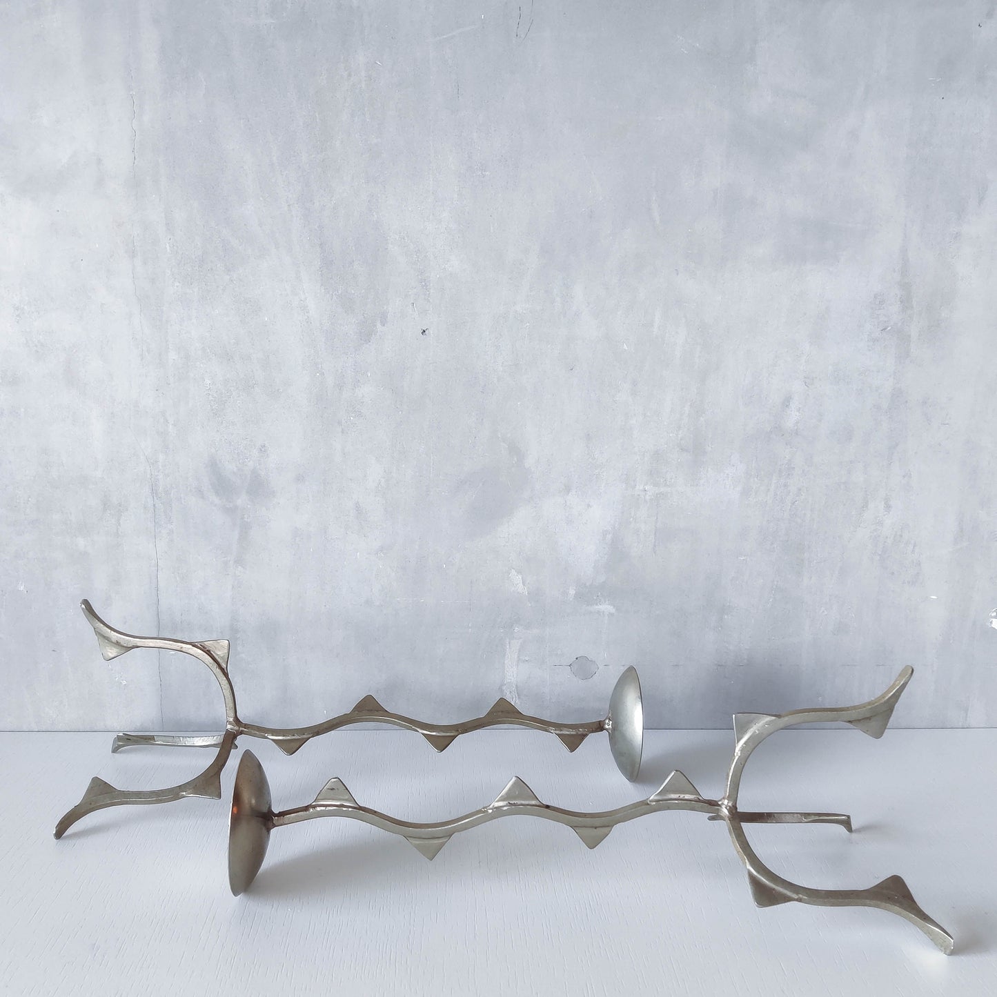 Pair of tall vintage sculptural wavy zigzag footed aluminium candle holders