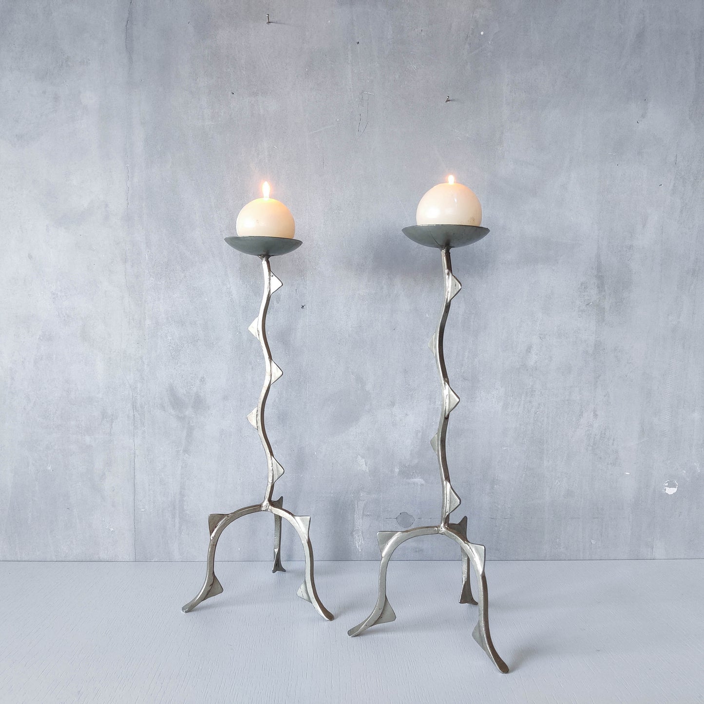 Pair of tall vintage sculptural wavy zigzag footed aluminium candle holders