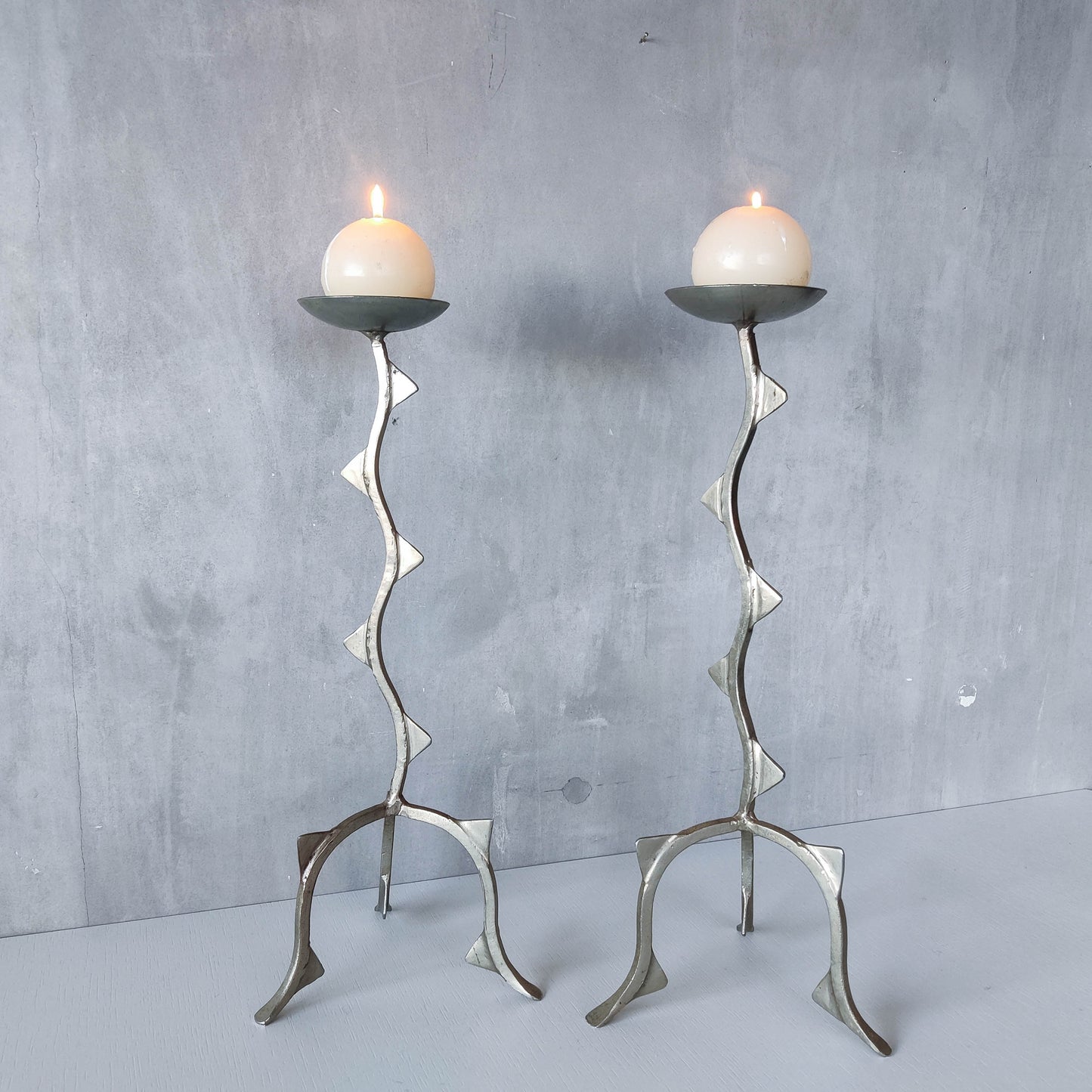 Pair of tall vintage sculptural wavy zigzag footed aluminium candle holders