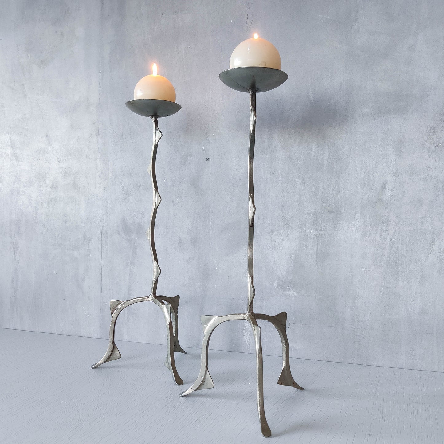 Pair of tall vintage sculptural wavy zigzag footed aluminium candle holders