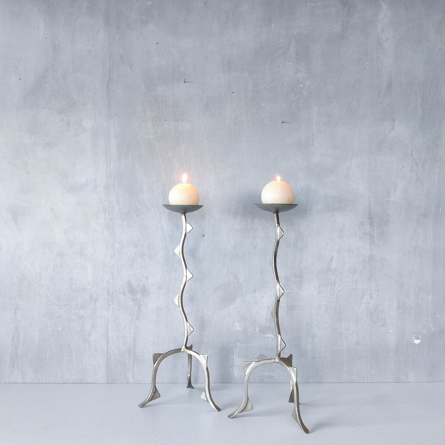 Pair of tall vintage sculptural wavy zigzag footed aluminium candle holders