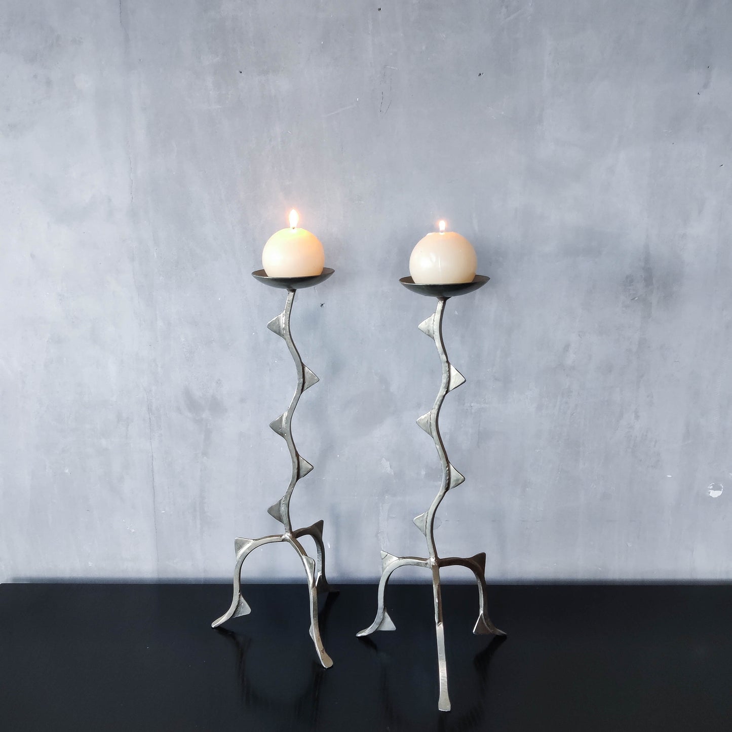 Pair of tall vintage sculptural wavy zigzag footed aluminium candle holders