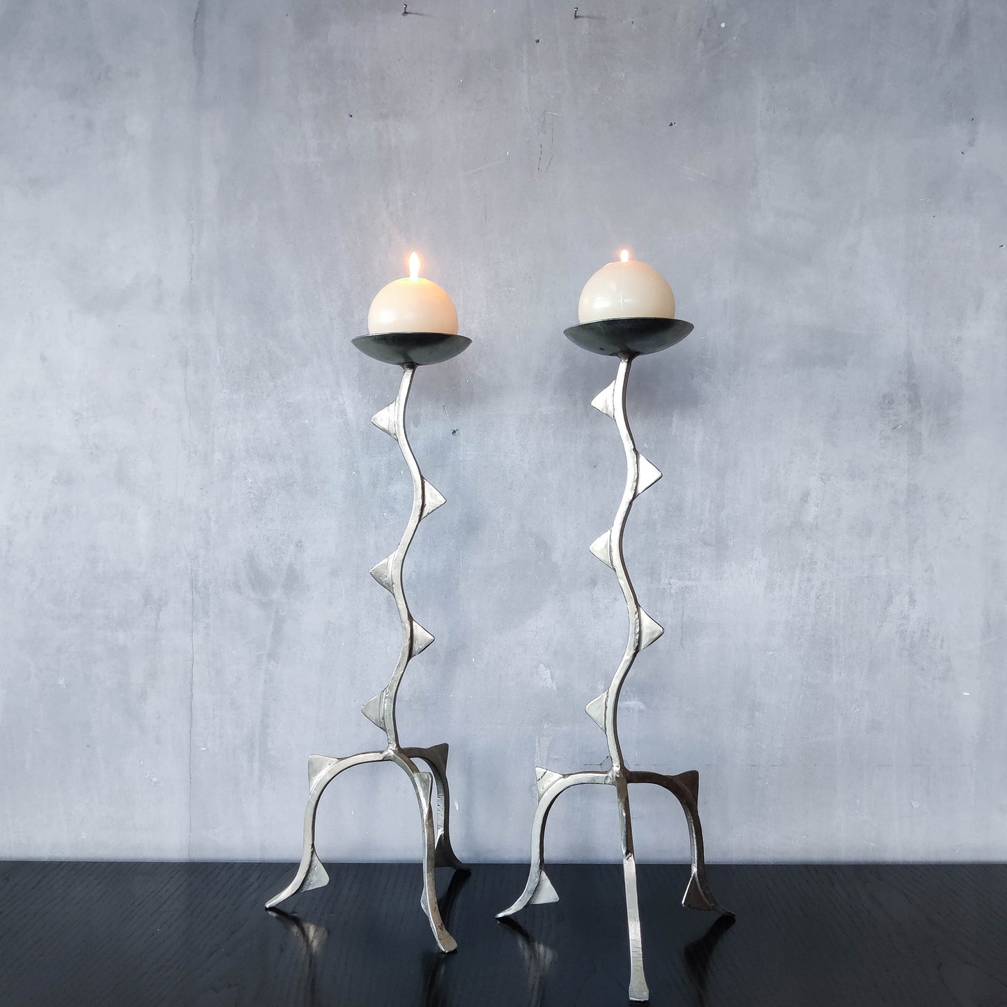 Pair of tall vintage sculptural wavy zigzag footed aluminium candle holders