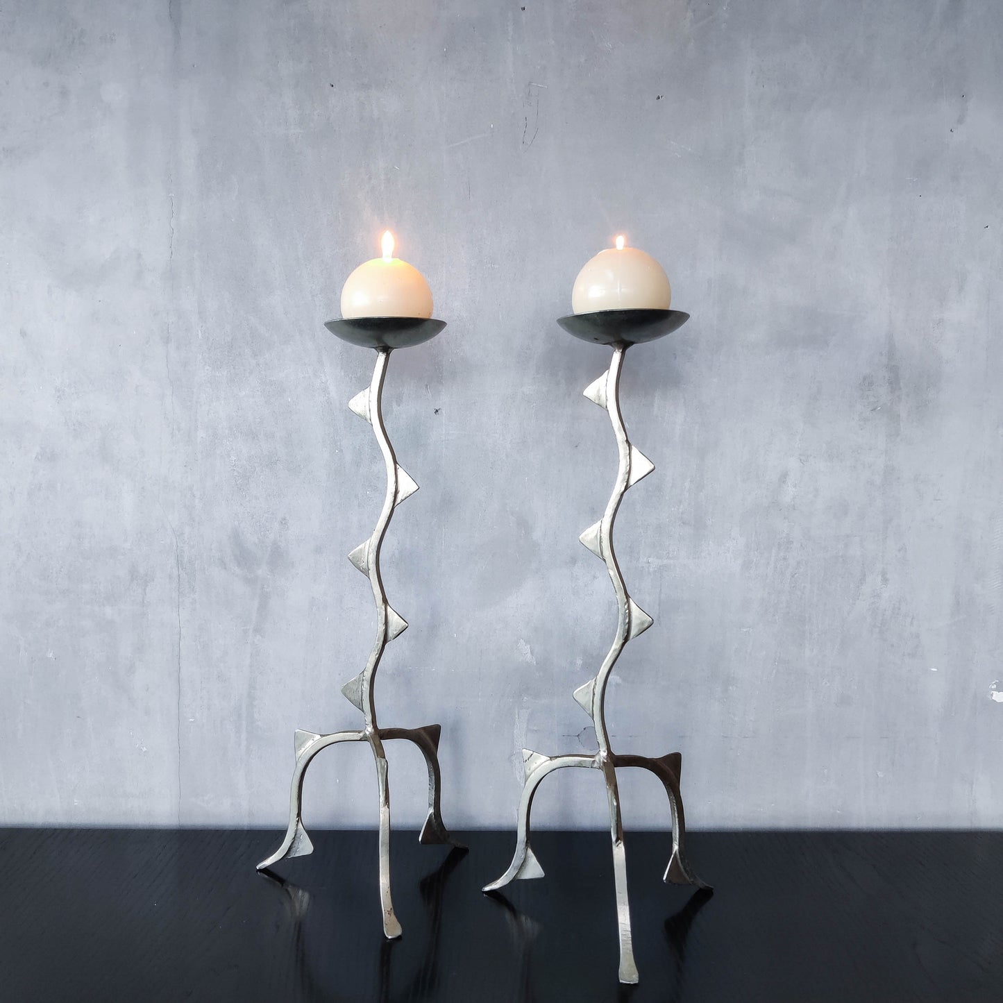 Pair of tall vintage sculptural wavy zigzag footed aluminium candle holders