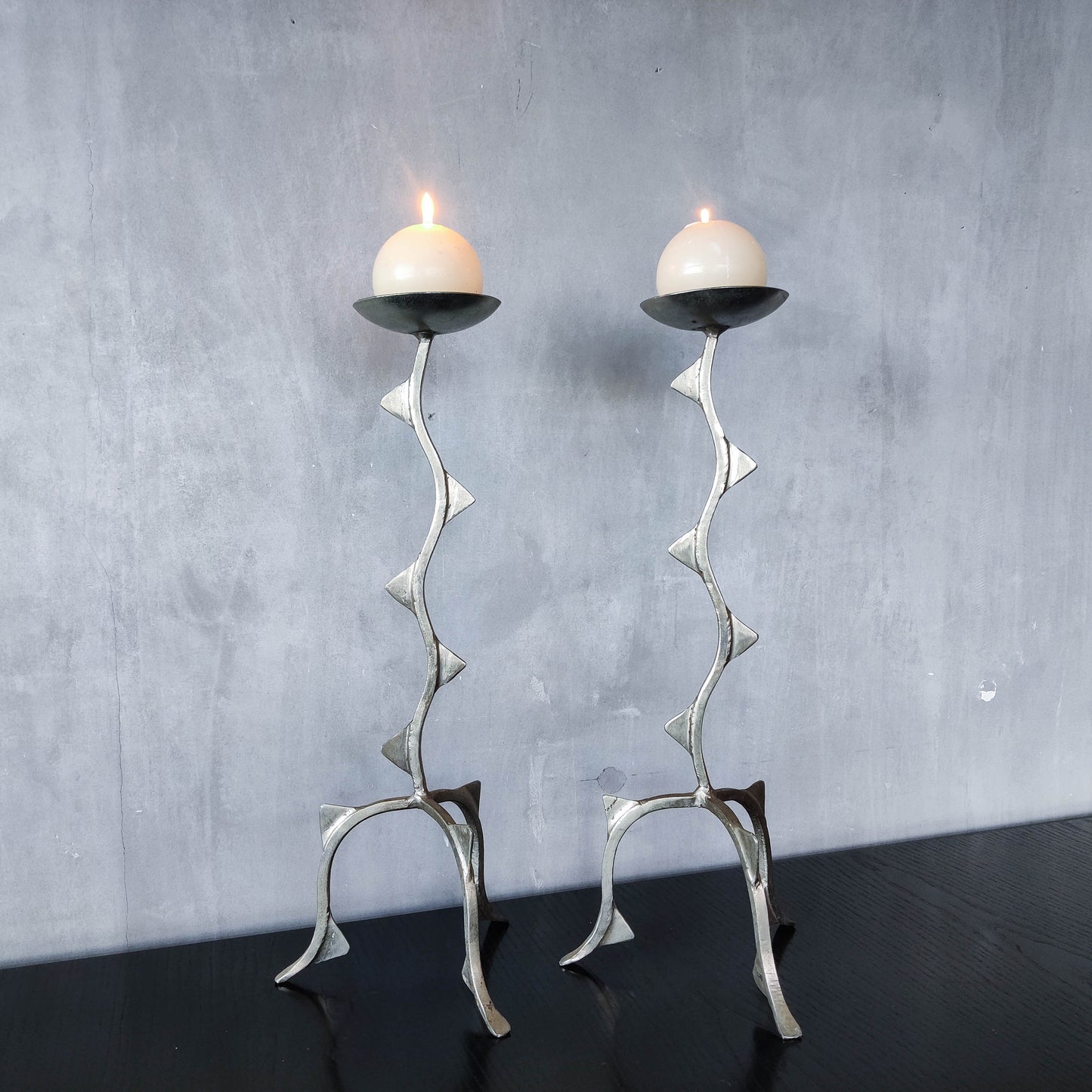 Pair of tall vintage sculptural wavy zigzag footed aluminium candle holders