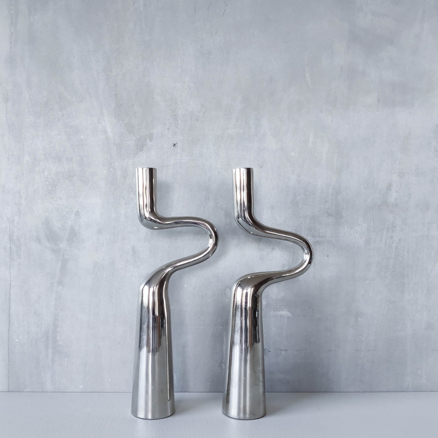 Pair of large curved chrome sculptural interlocking candle holders