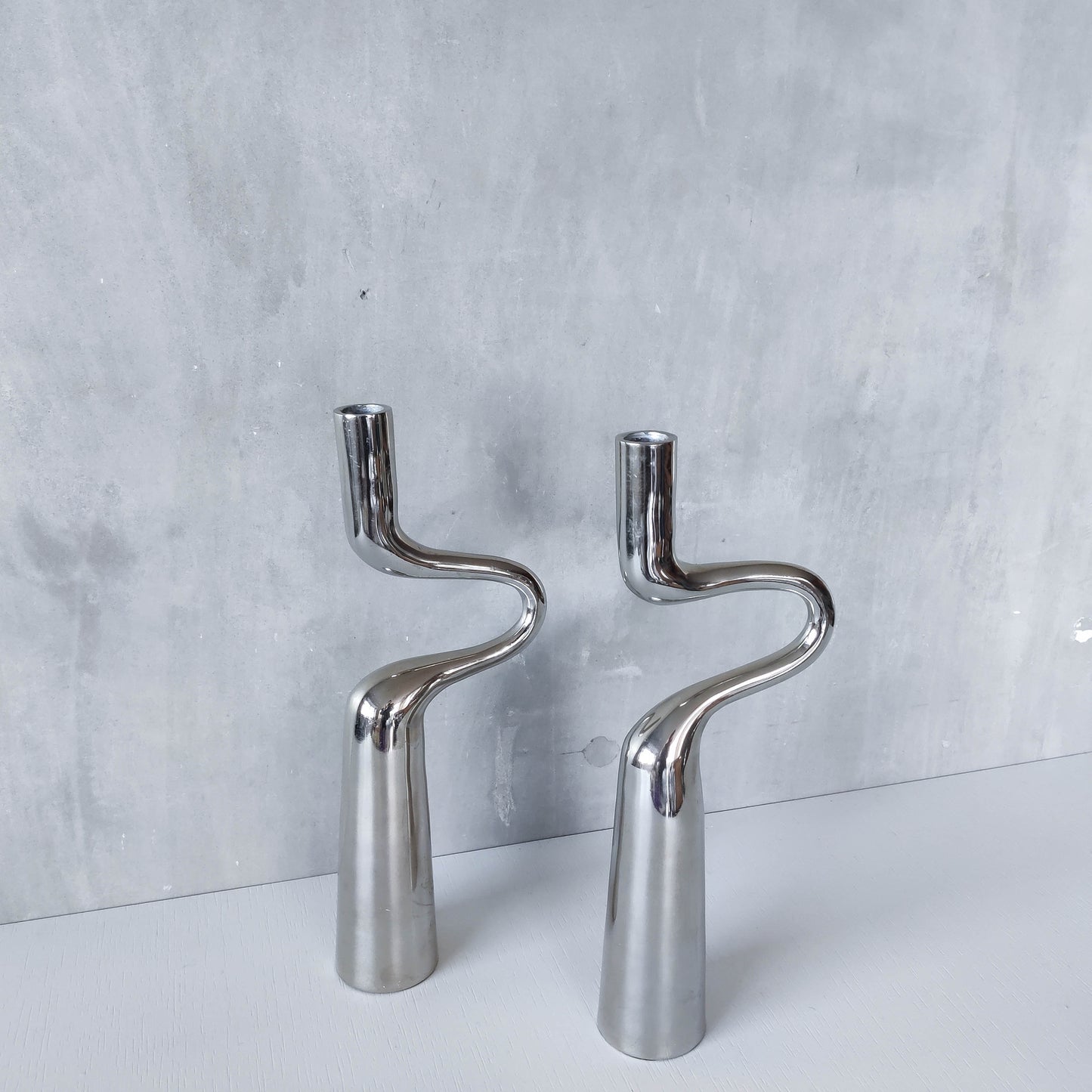 Pair of large curved chrome sculptural interlocking candle holders