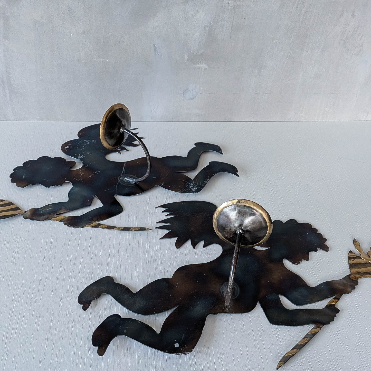 Pair of vintage metalwork torch cut steel cherub wall candle sconces