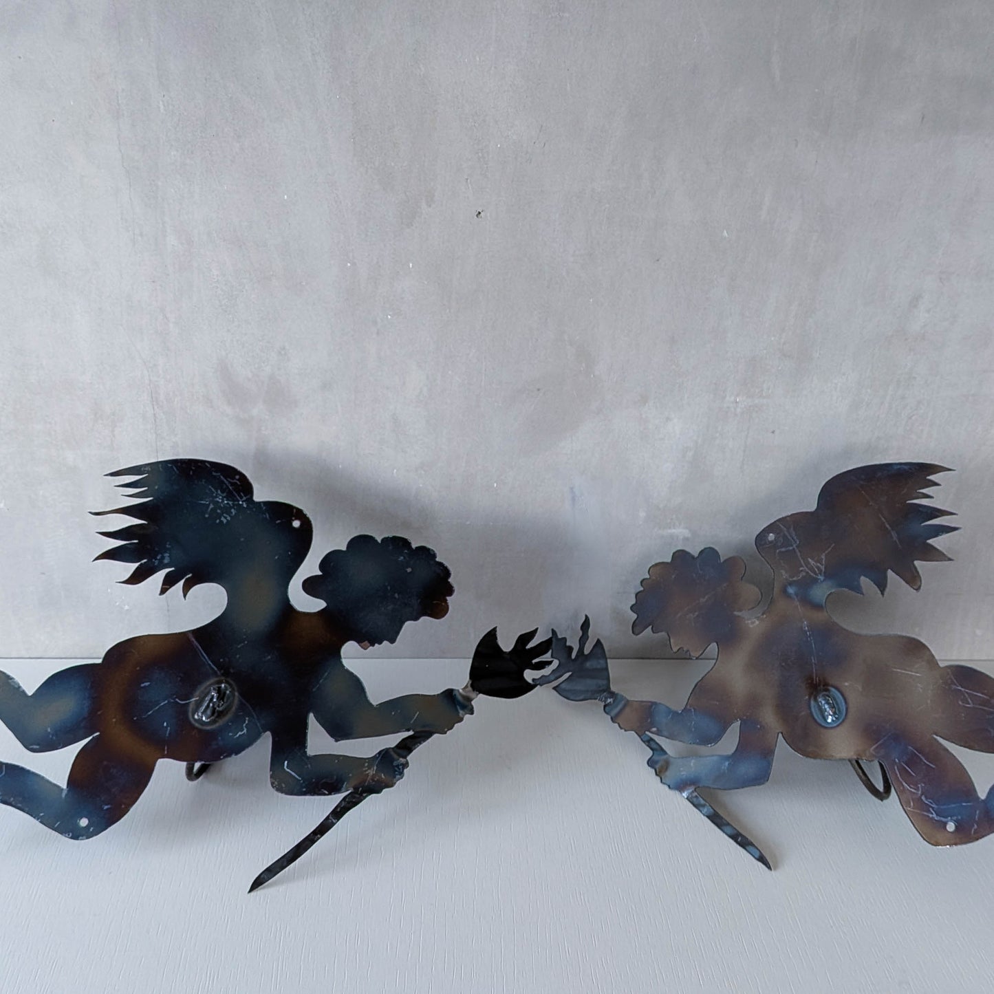 Pair of vintage metalwork torch cut steel cherub wall candle sconces