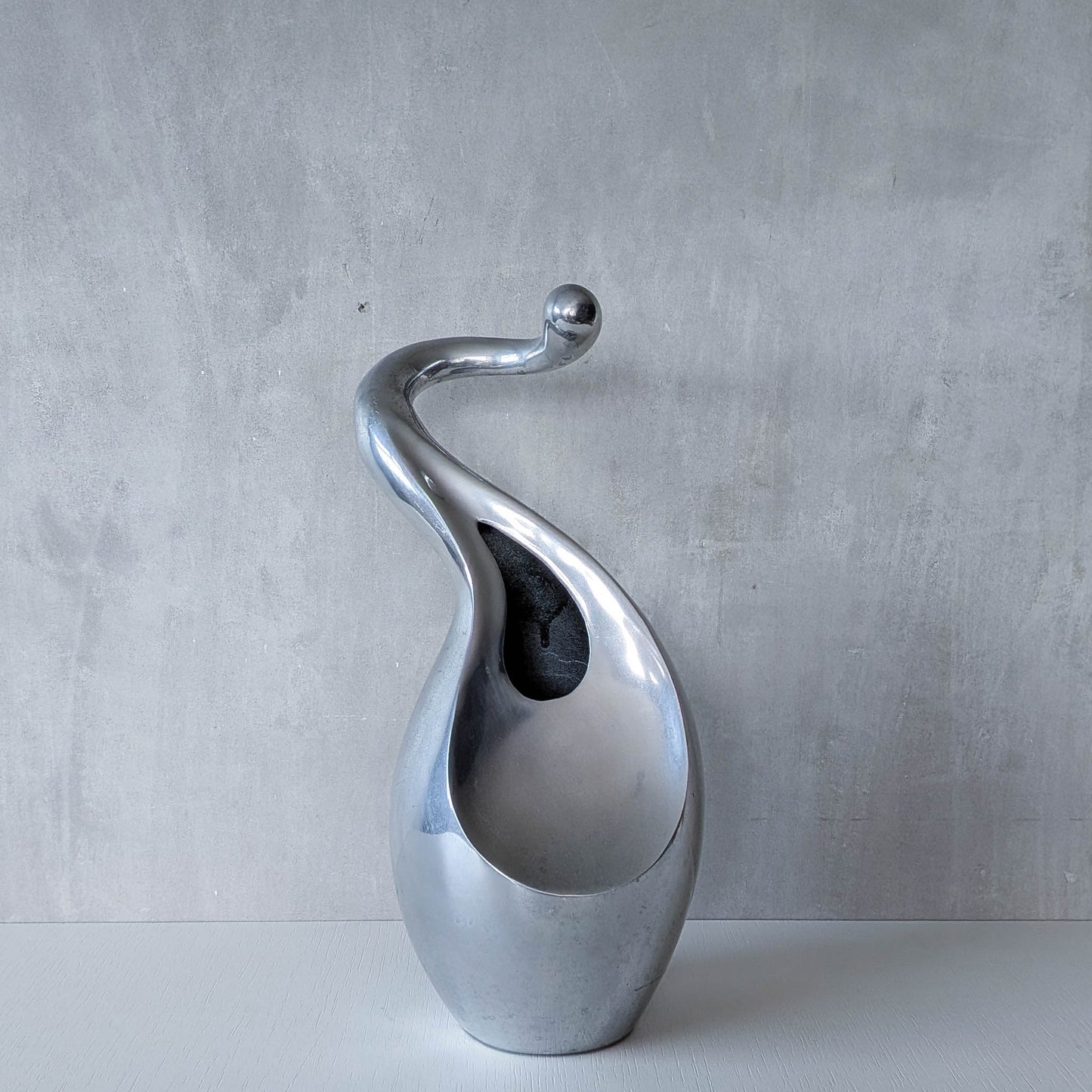 A vintage cast aluminium abstract surrealist twisted vase vessel