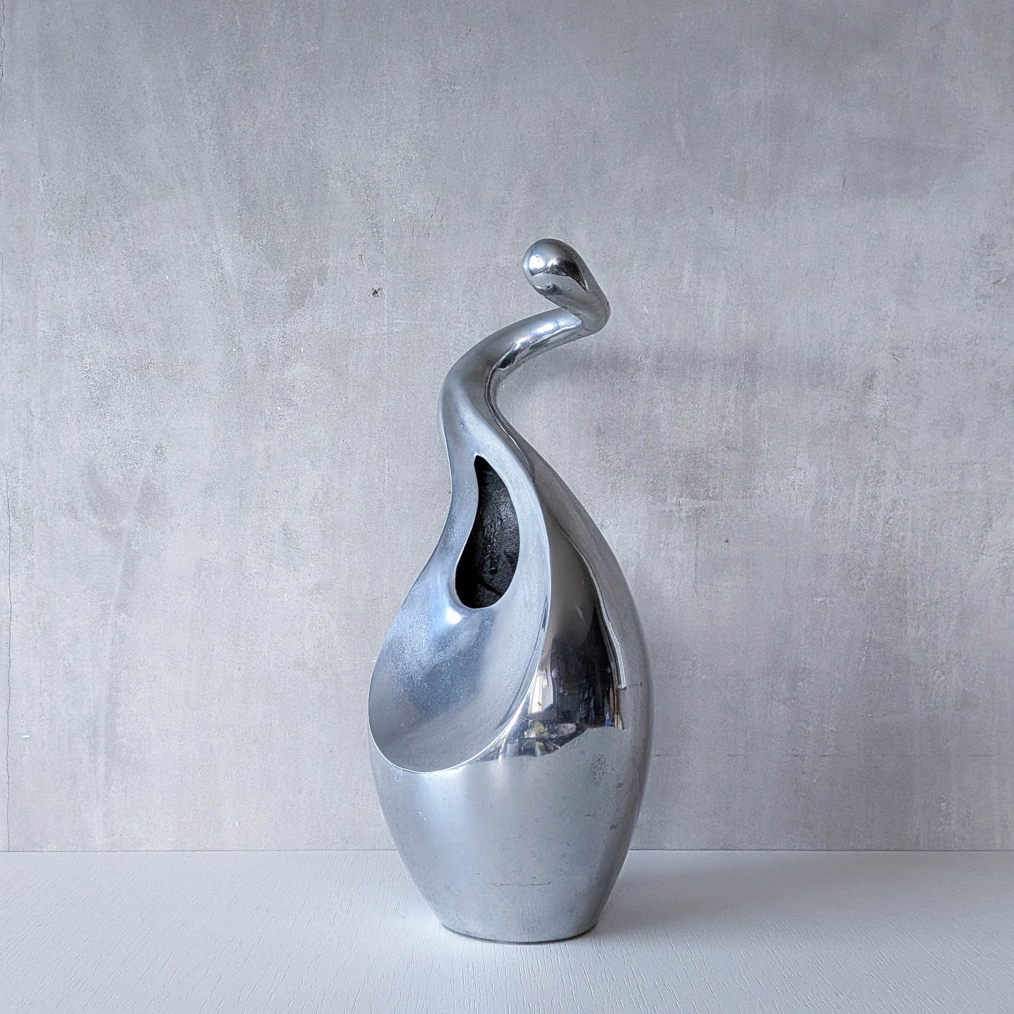 A vintage cast aluminium abstract surrealist twisted vase vessel