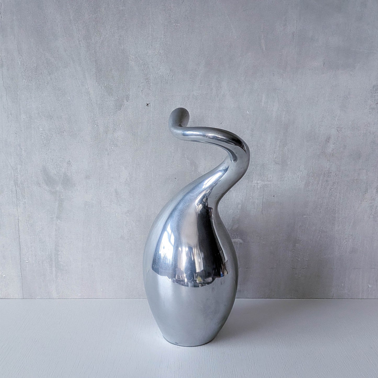 A vintage cast aluminium abstract surrealist twisted vase vessel