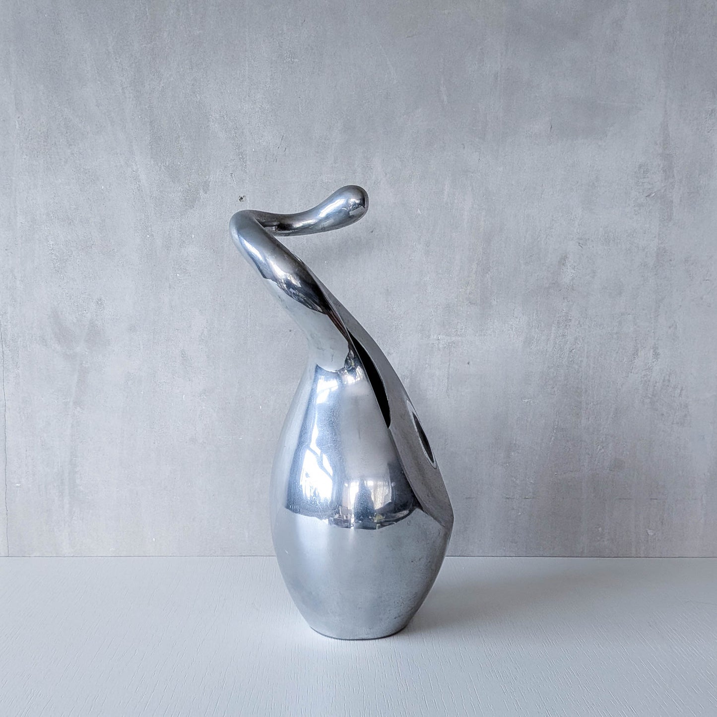 A vintage cast aluminium abstract surrealist twisted vase vessel