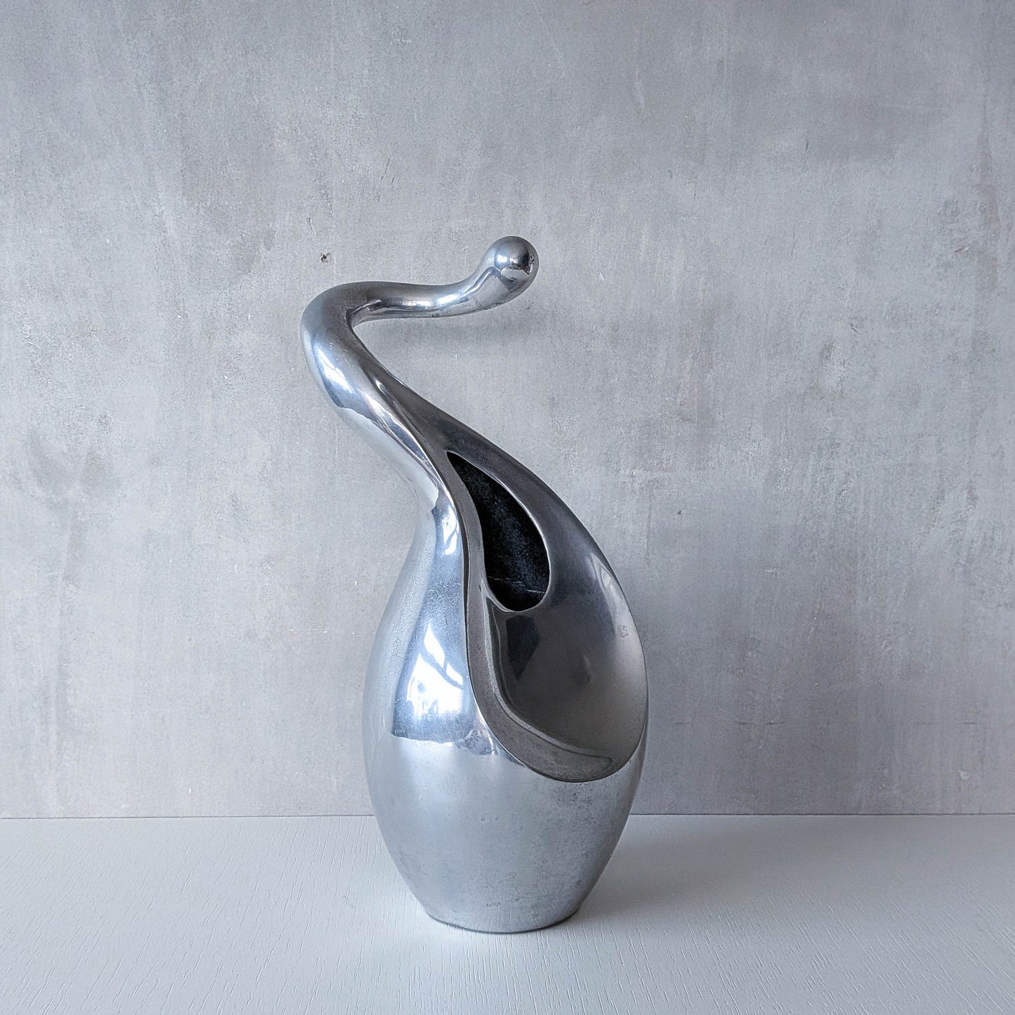 A vintage cast aluminium abstract surrealist twisted vase vessel