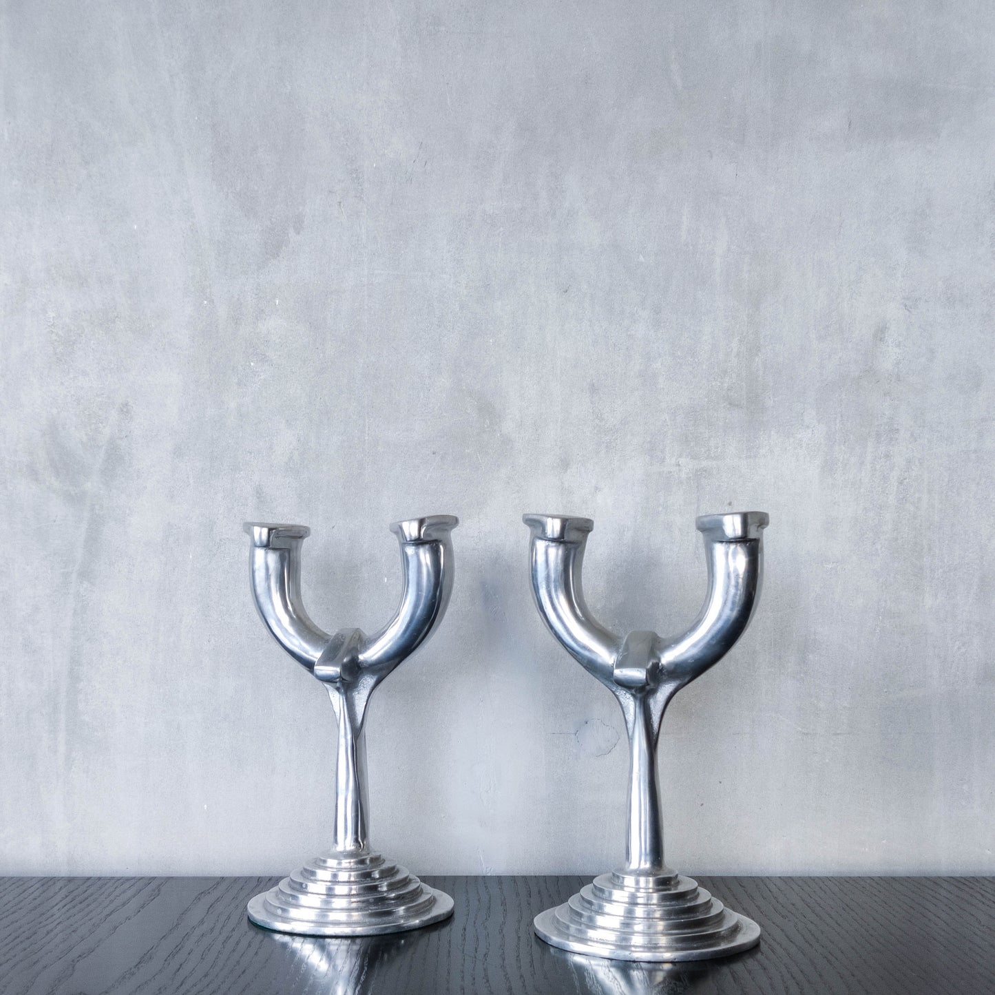 Vintage cast aluminium modernist sculptural pair of candelabras with stepped bases