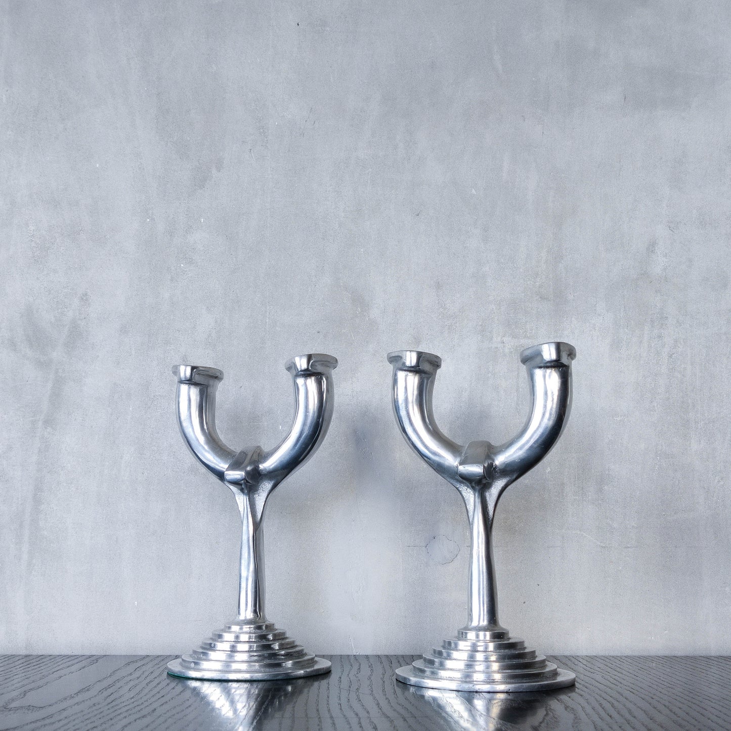 Vintage cast aluminium modernist sculptural pair of candelabras with stepped bases