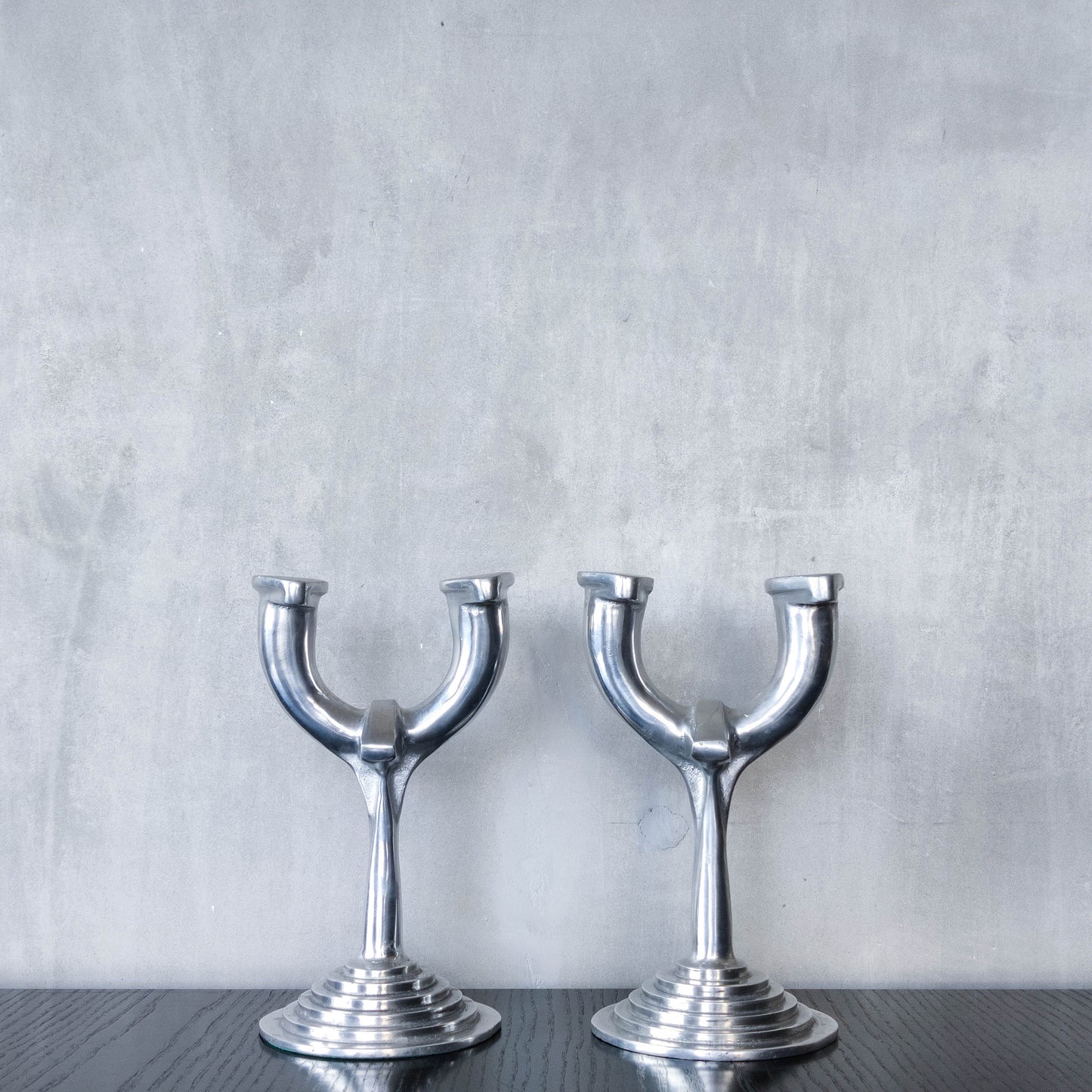 Vintage cast aluminium modernist sculptural pair of candelabras with stepped bases