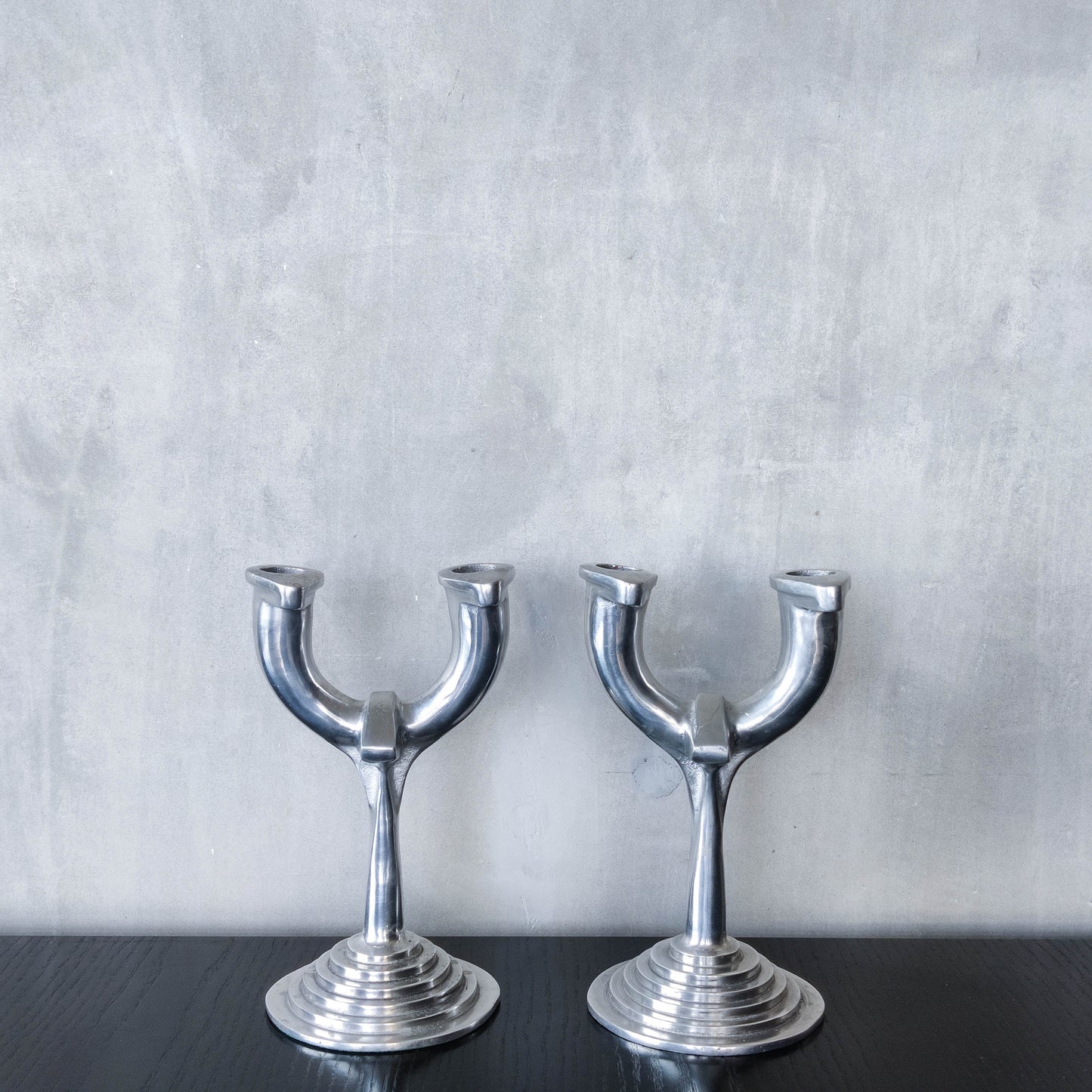 Vintage cast aluminium modernist sculptural pair of candelabras with stepped bases