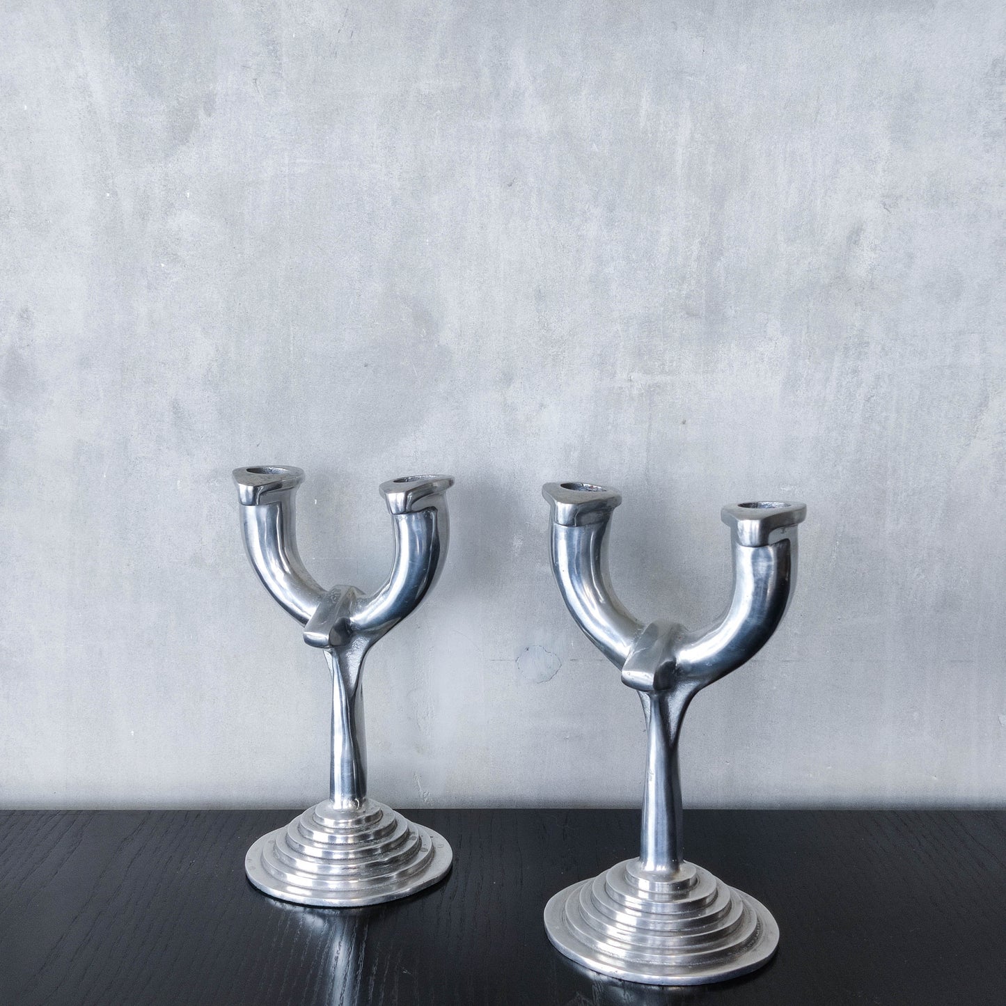 Vintage cast aluminium modernist sculptural pair of candelabras with stepped bases
