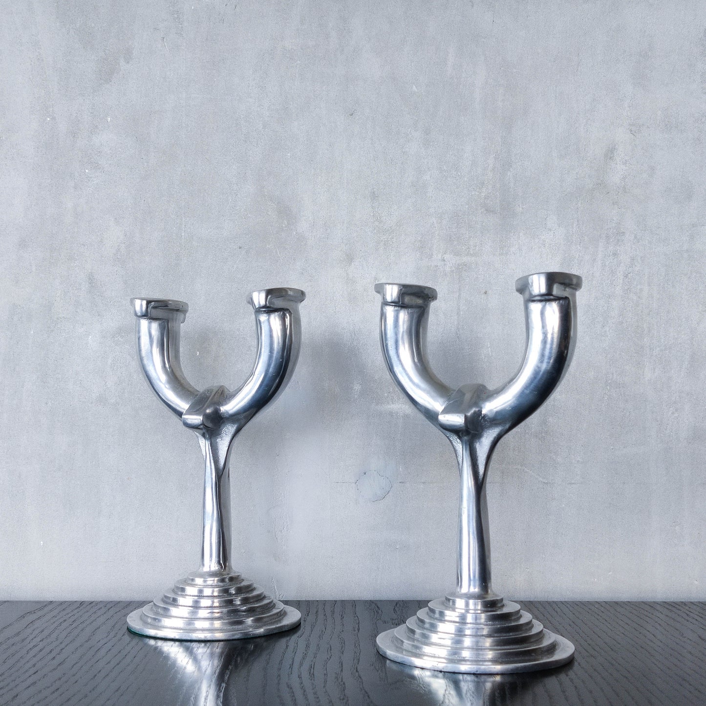 Vintage cast aluminium modernist sculptural pair of candelabras with stepped bases