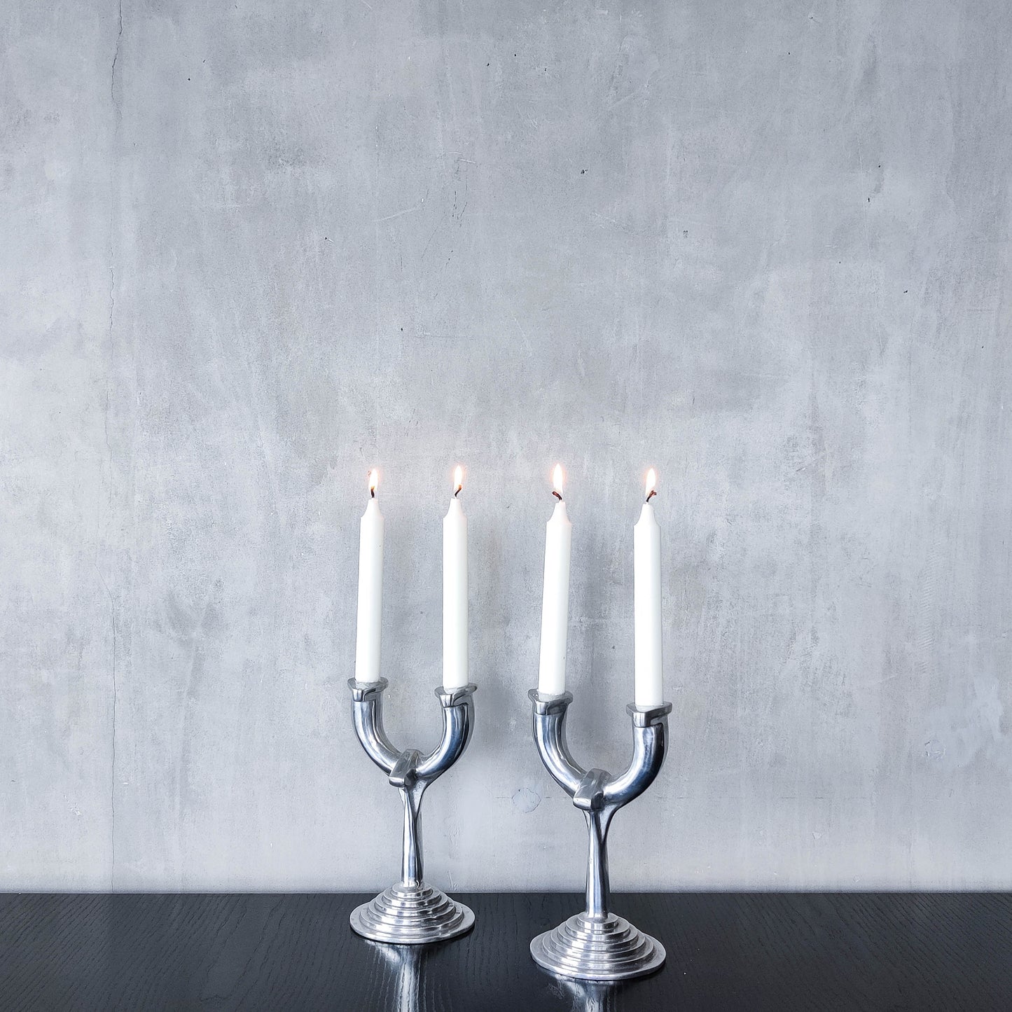 Vintage cast aluminium modernist sculptural pair of candelabras with stepped bases
