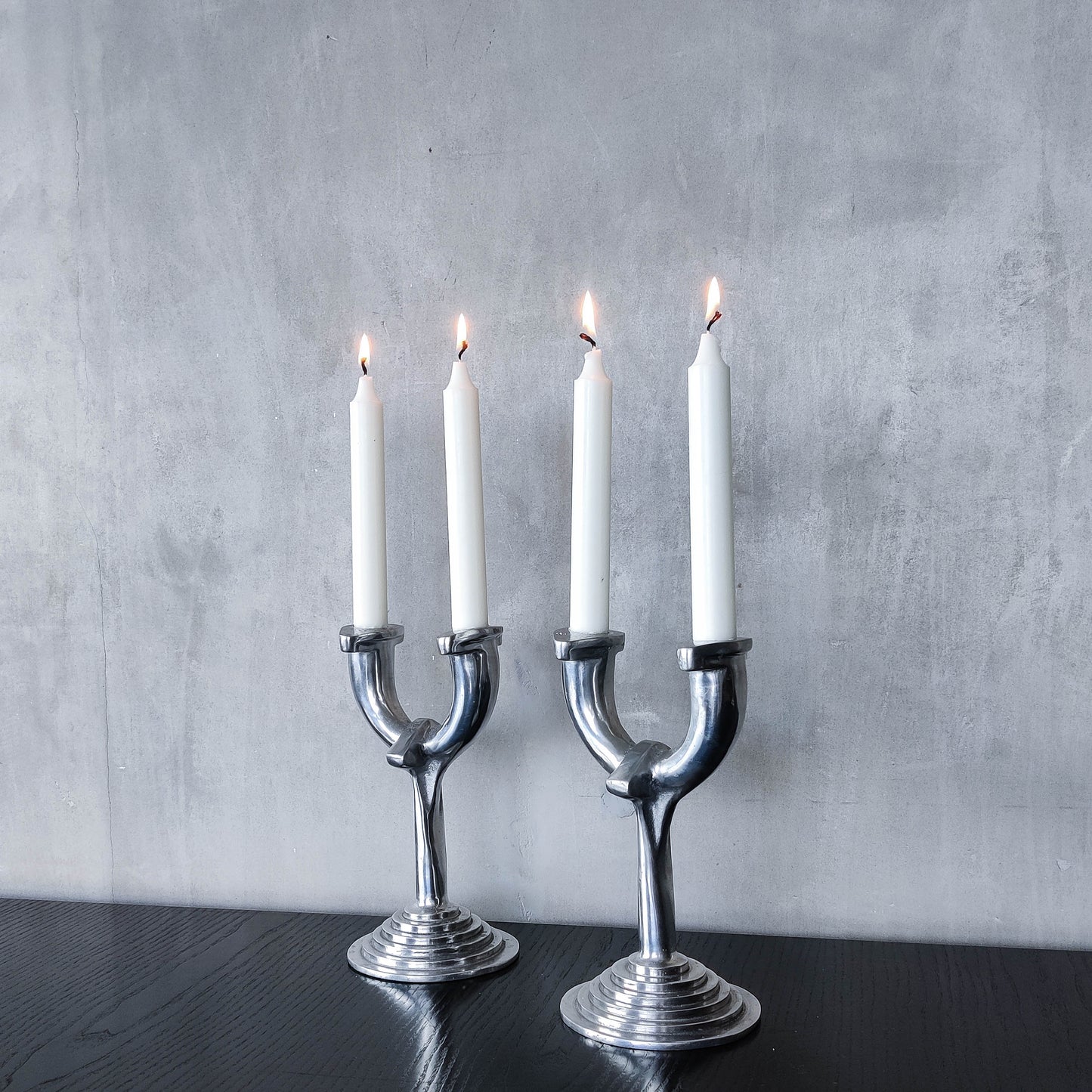 Vintage cast aluminium modernist sculptural pair of candelabras with stepped bases