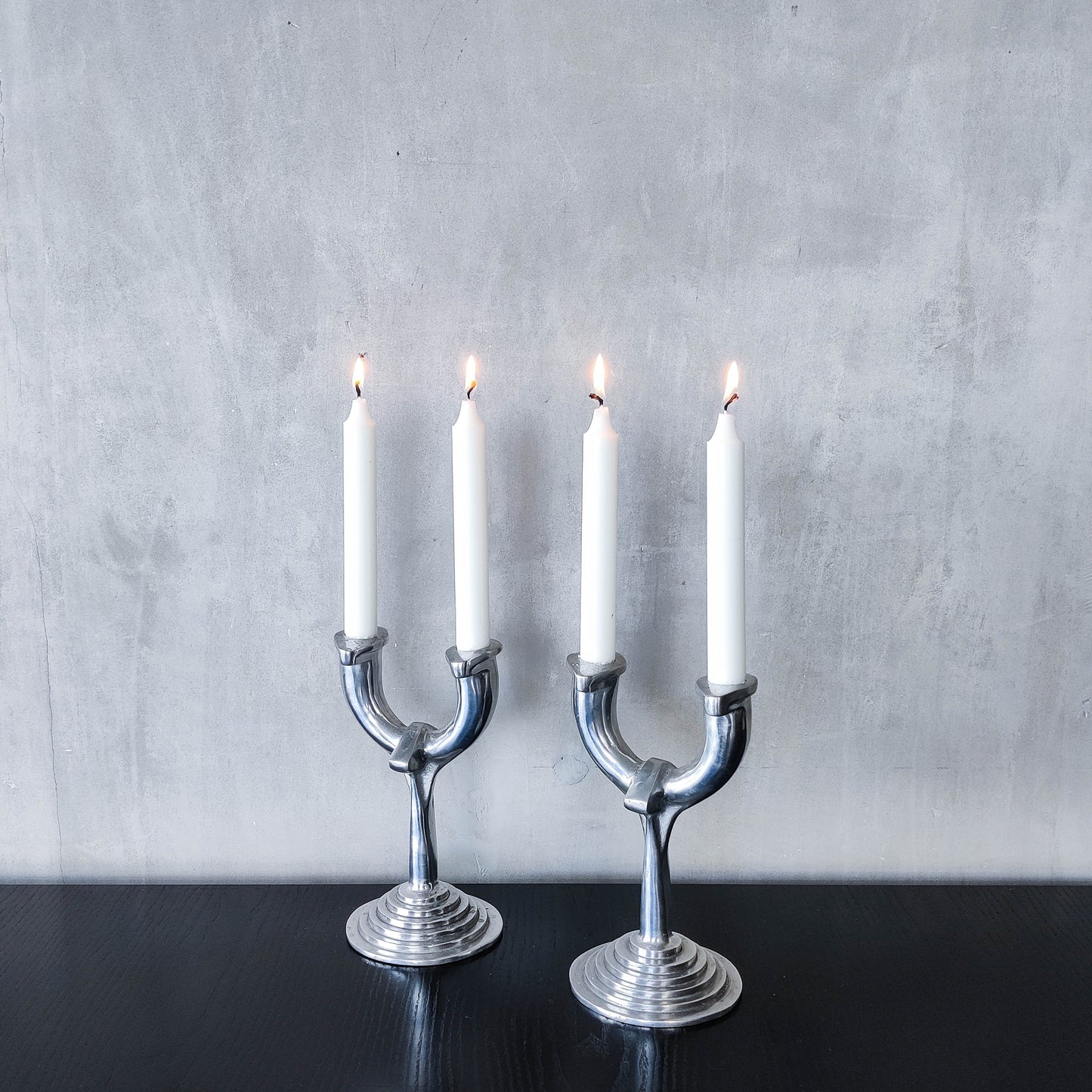 Vintage cast aluminium modernist sculptural pair of candelabras with stepped bases