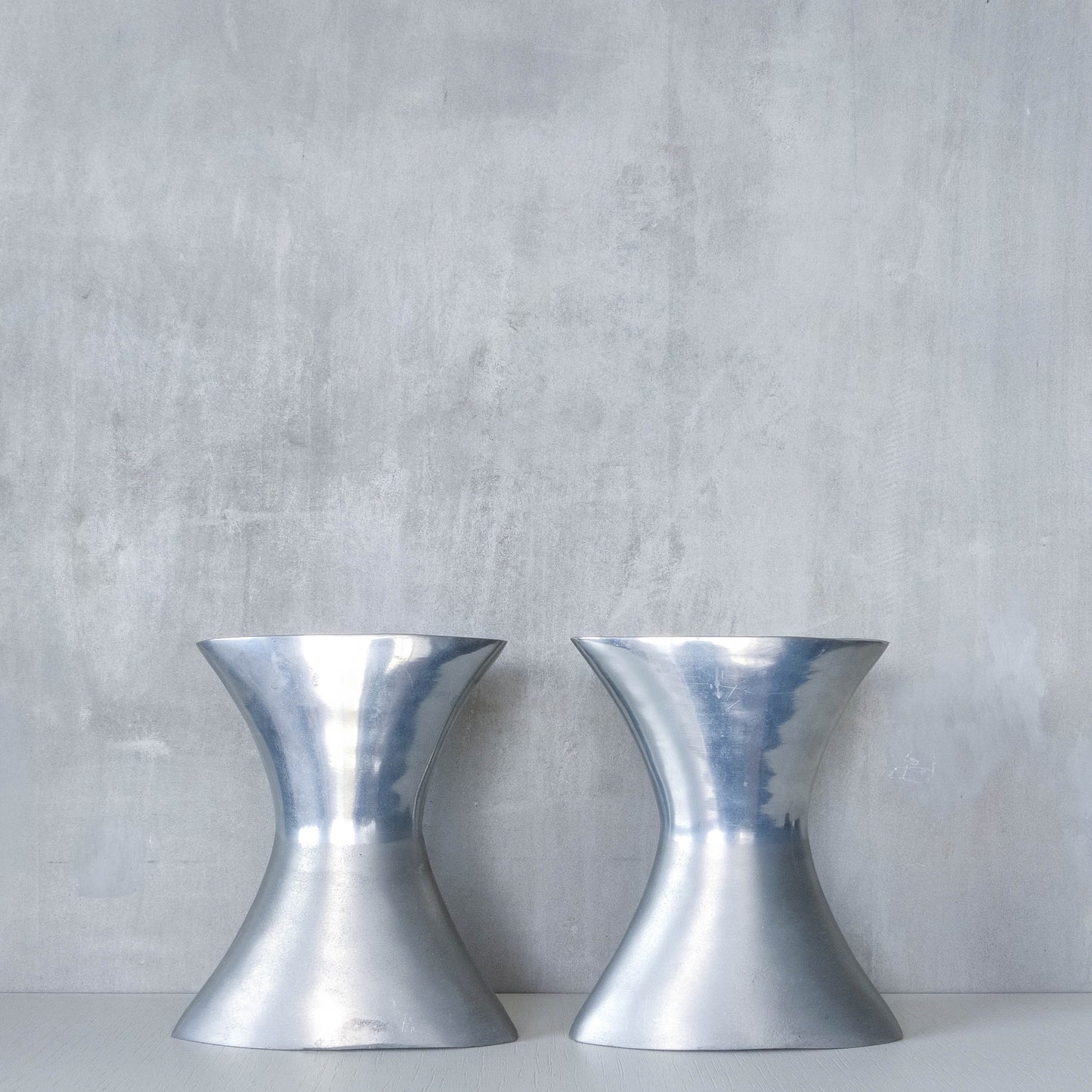 A pair of vintage sculptural cast aluminium flattened vases