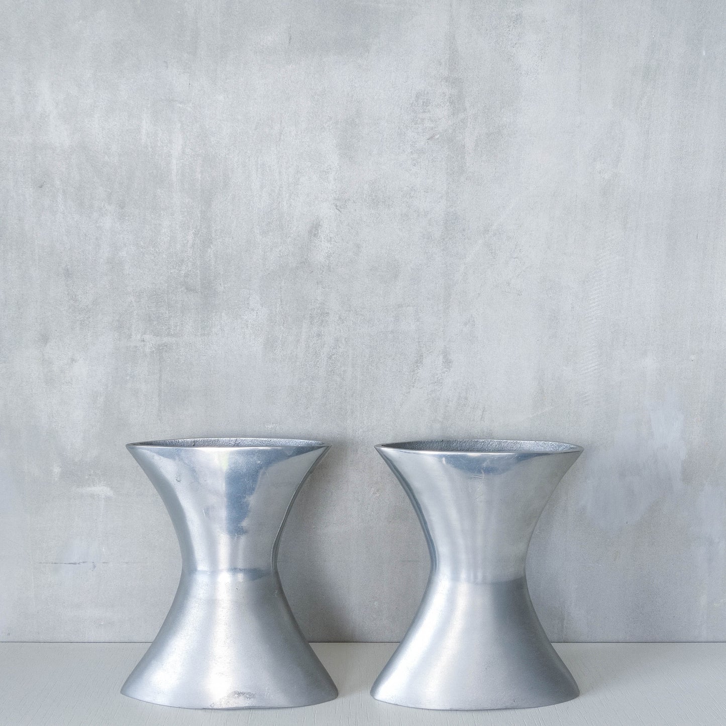 A pair of vintage sculptural cast aluminium flattened vases
