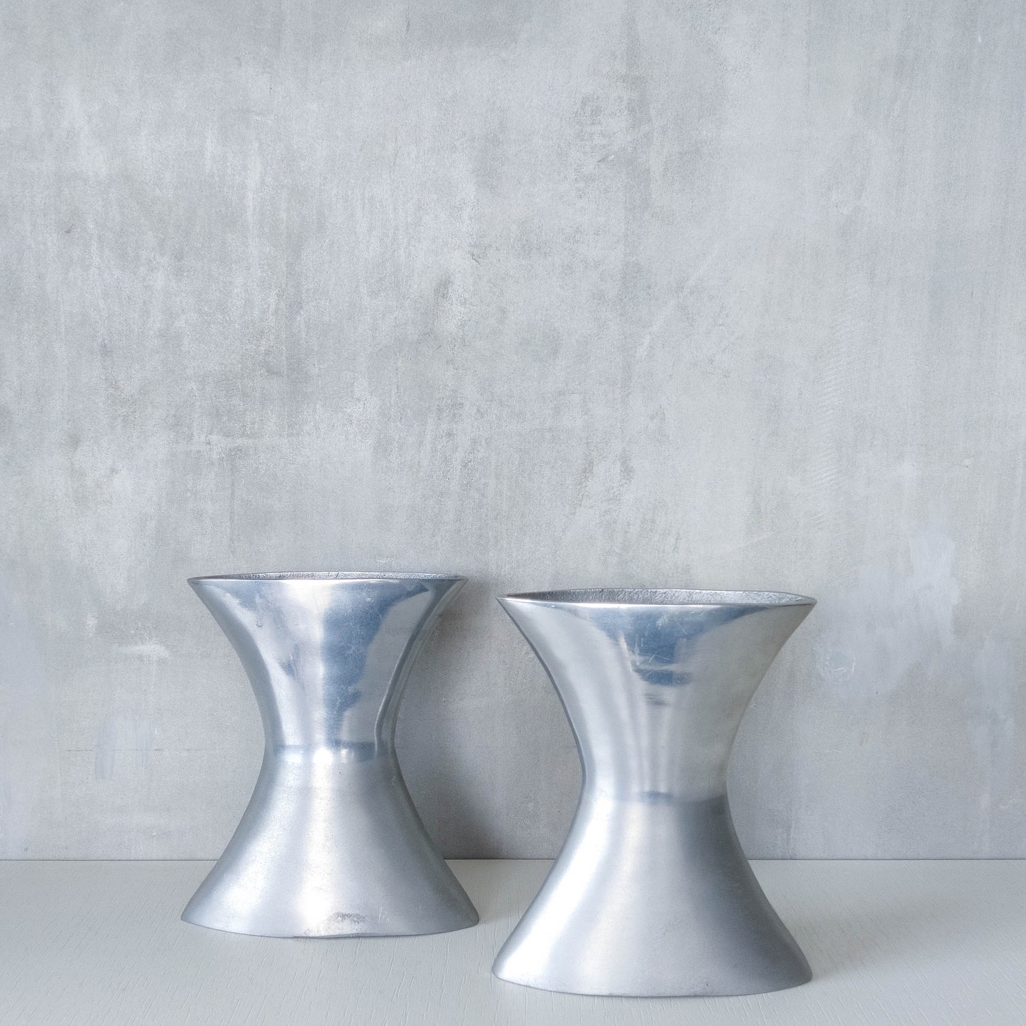 A pair of vintage sculptural cast aluminium flattened vases
