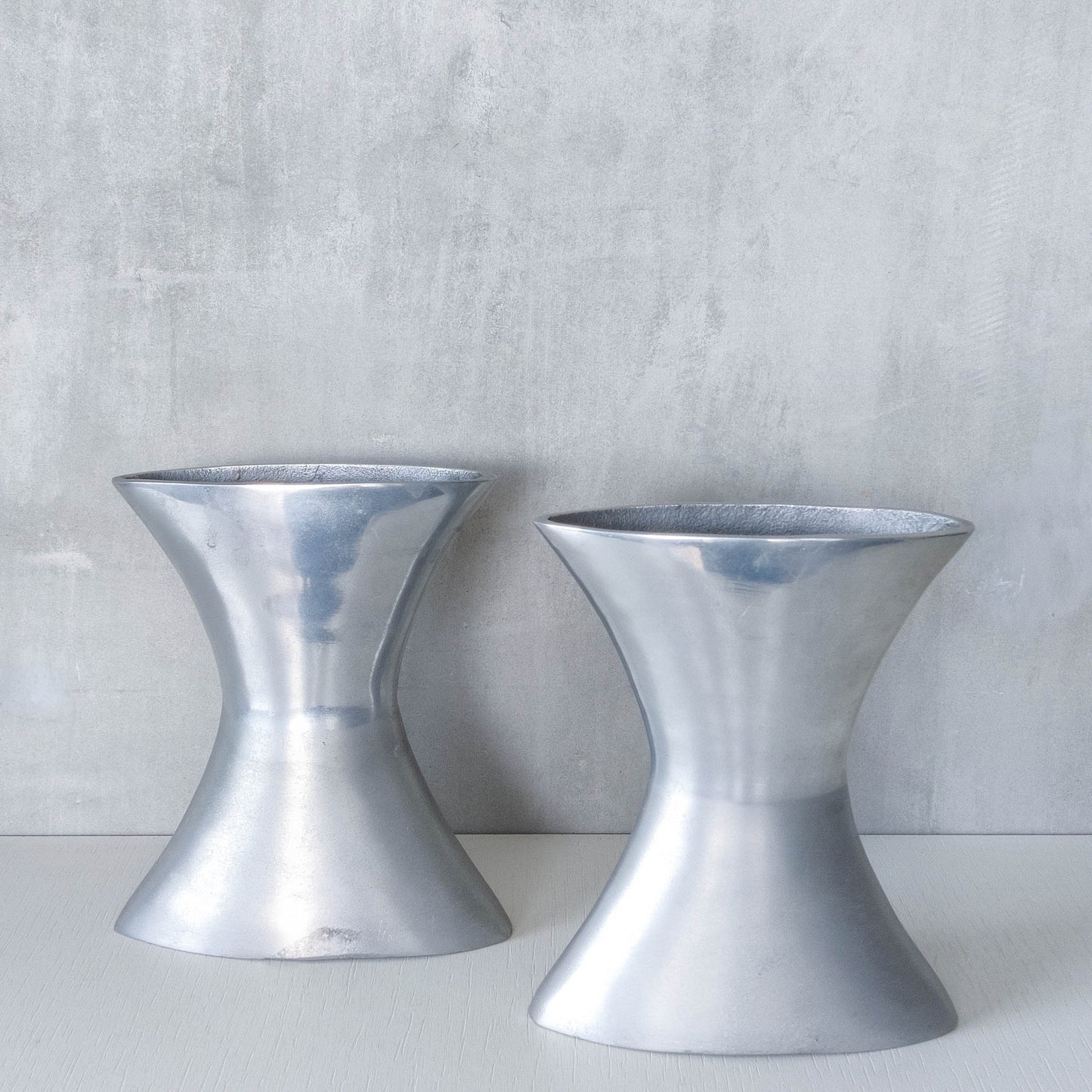 A pair of vintage sculptural cast aluminium flattened vases
