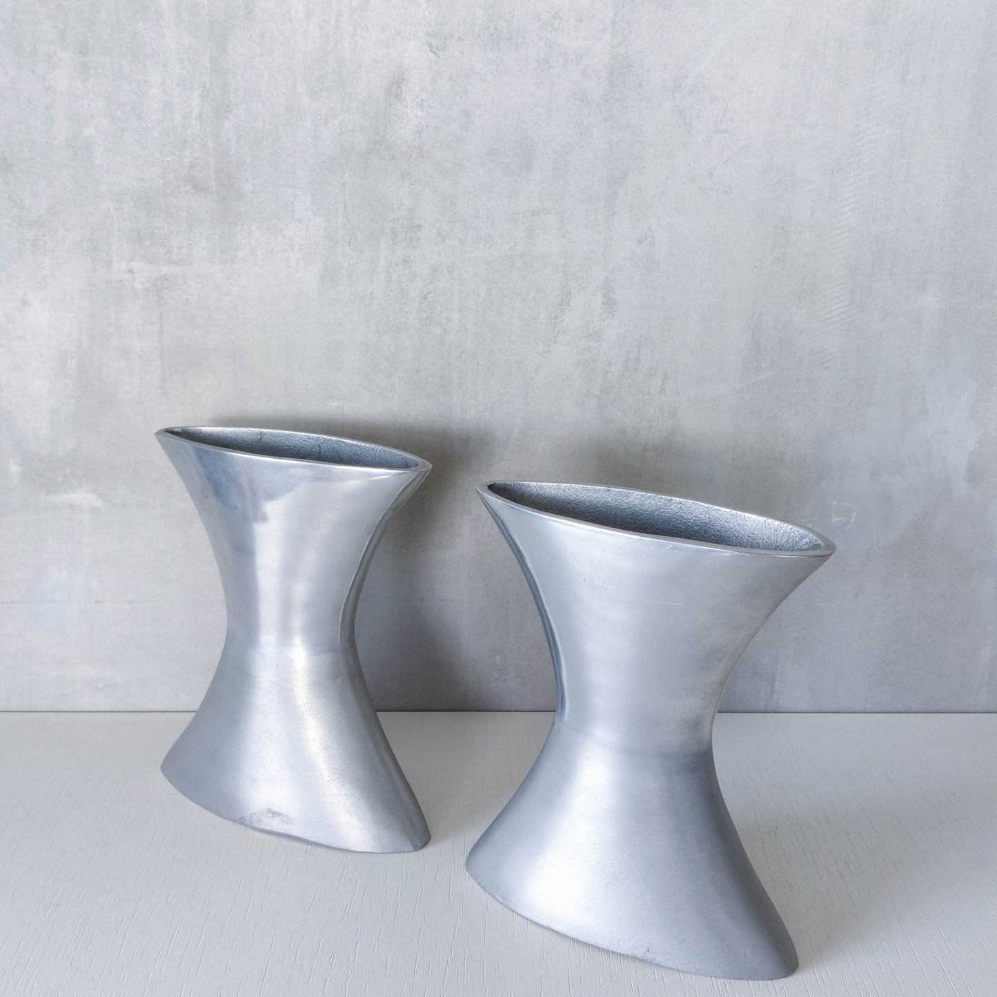A pair of vintage sculptural cast aluminium flattened vases