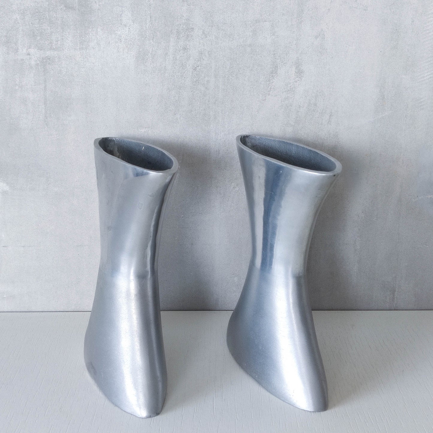 A pair of vintage sculptural cast aluminium flattened vases