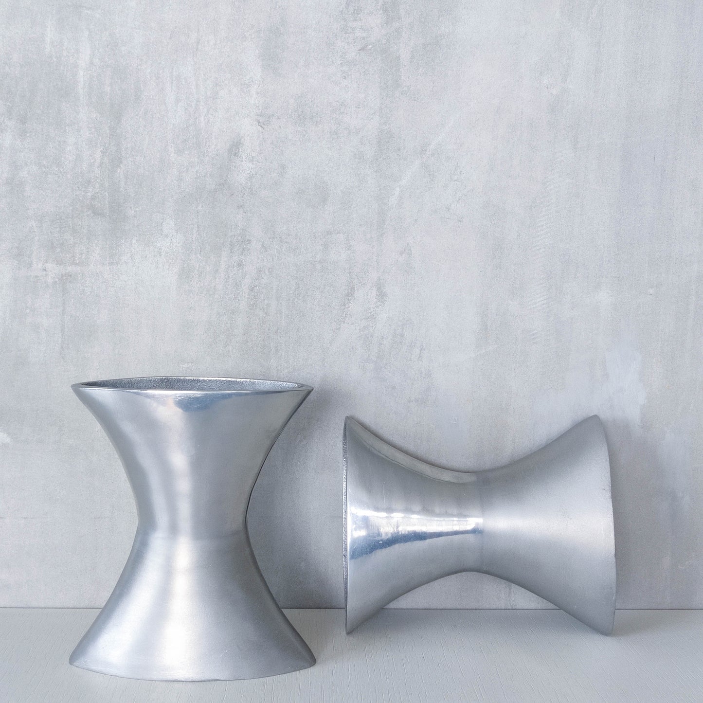 A pair of vintage sculptural cast aluminium flattened vases