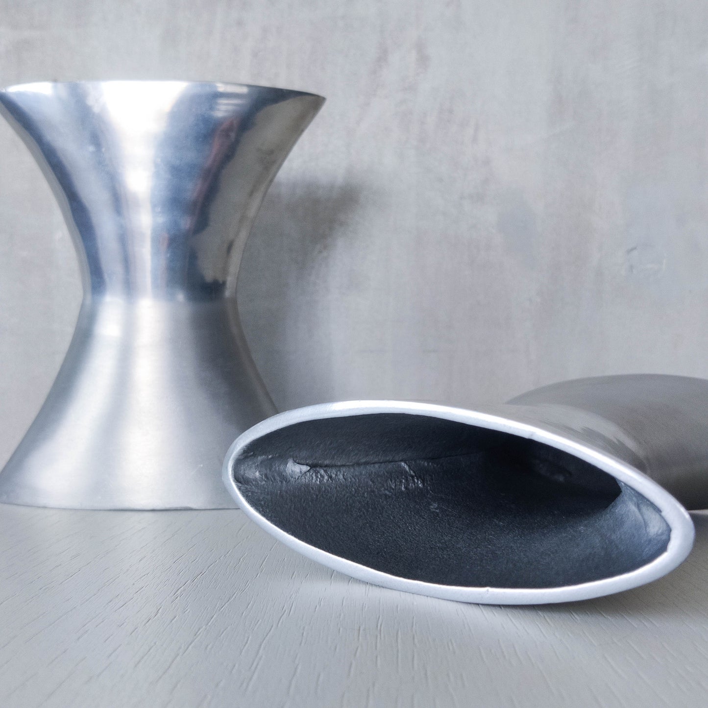 A pair of vintage sculptural cast aluminium flattened vases