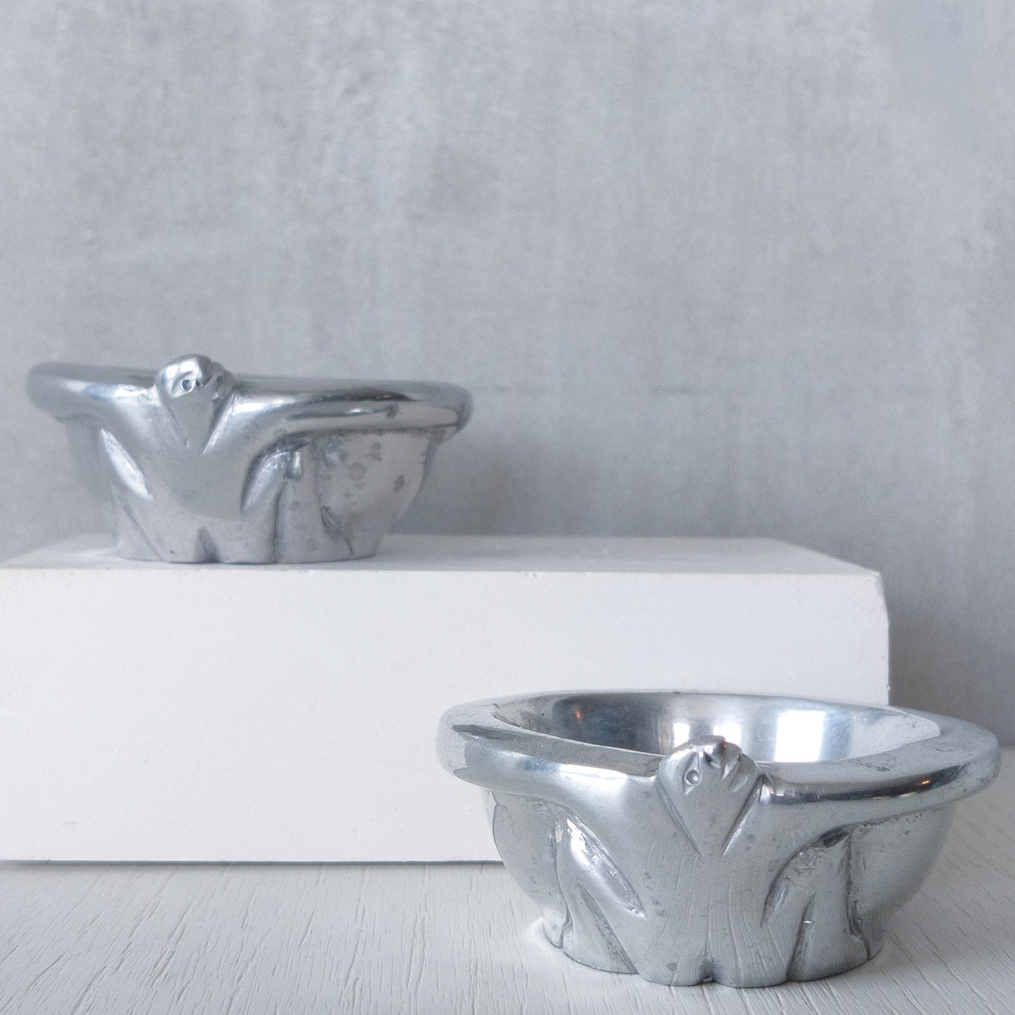 A pair of Carrol Boyes small figural cast aluminium bowls or tea light holders