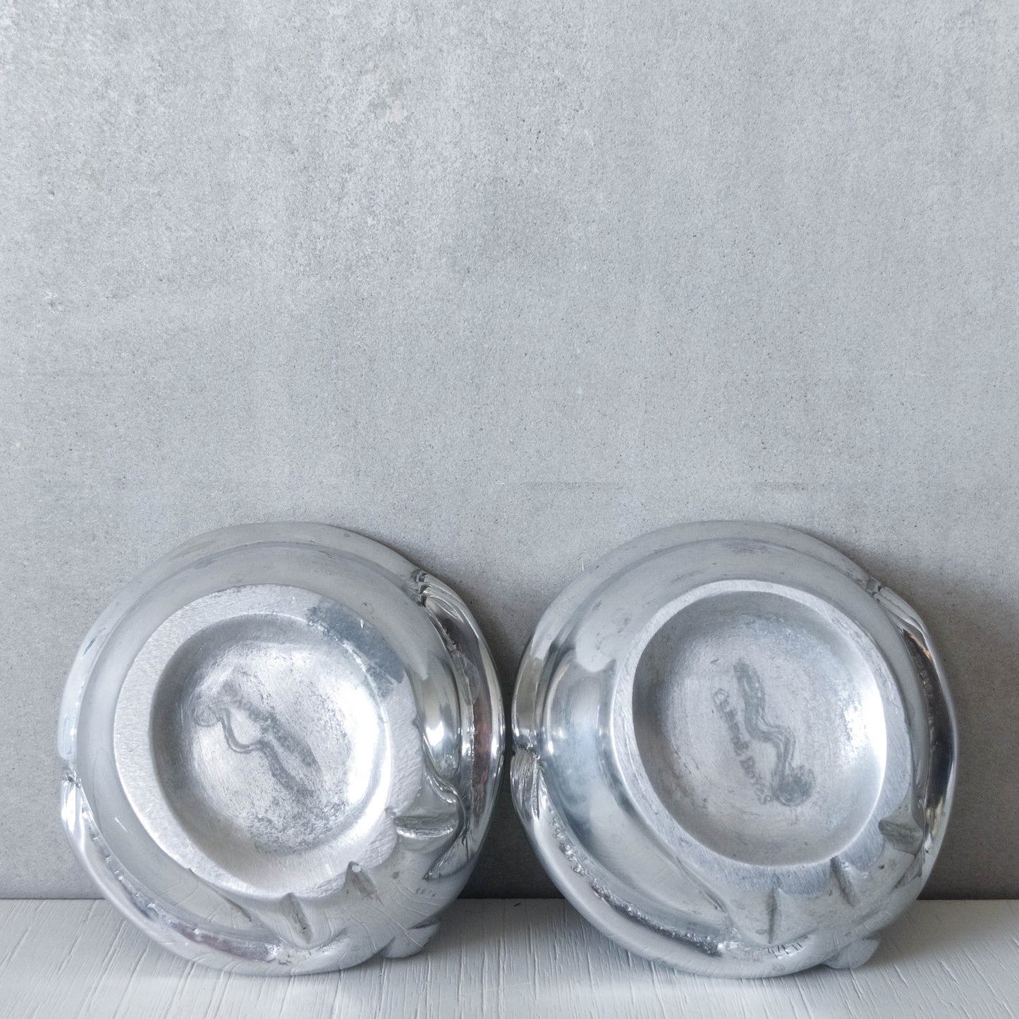 A pair of Carrol Boyes small figural cast aluminium bowls or tea light holders