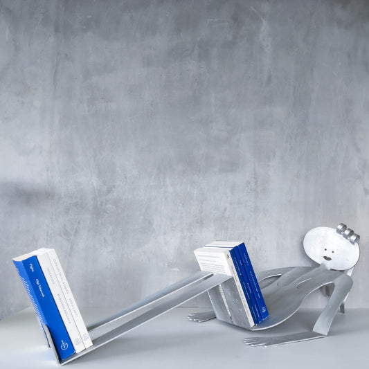 A large vintage 1990s postmodern Fred Garbotz figural brushed aluminium book or record rack