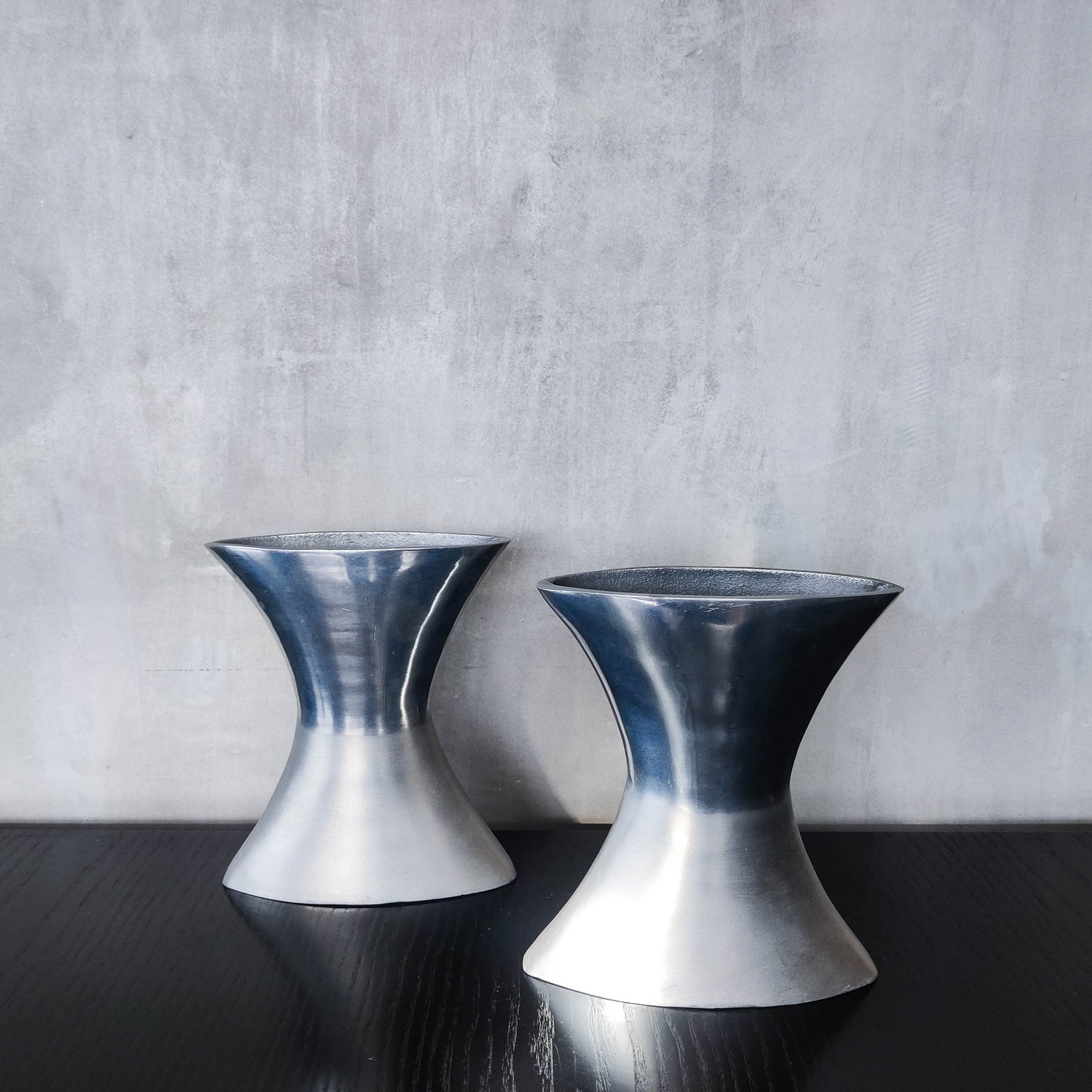 A pair of vintage sculptural cast aluminium flattened vases