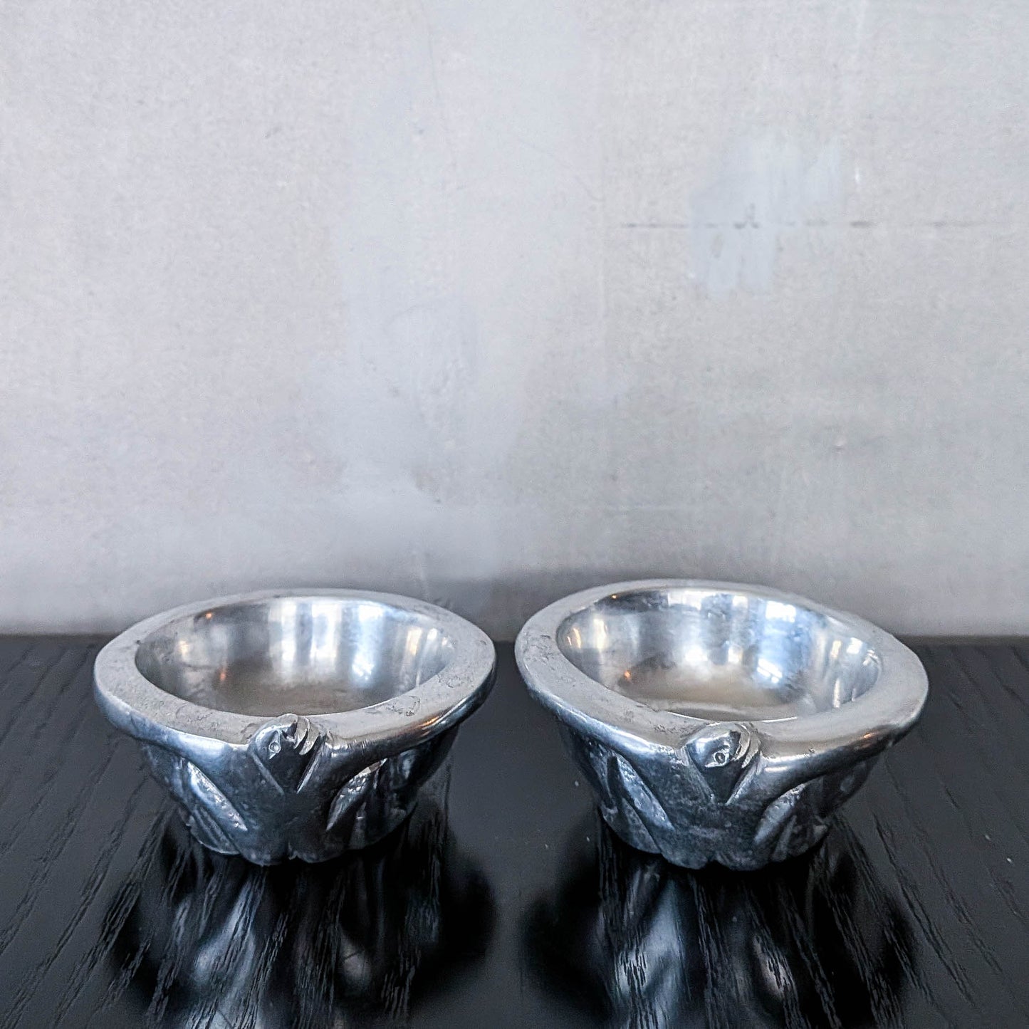 A pair of Carrol Boyes small figural cast aluminium bowls or tea light holders