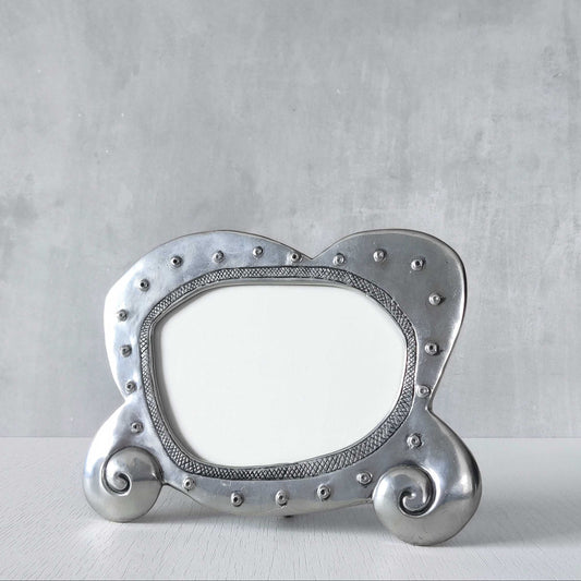 An early 1990s Carrol Boyes sculptural cast pewter photo frame with scrollwork feet
