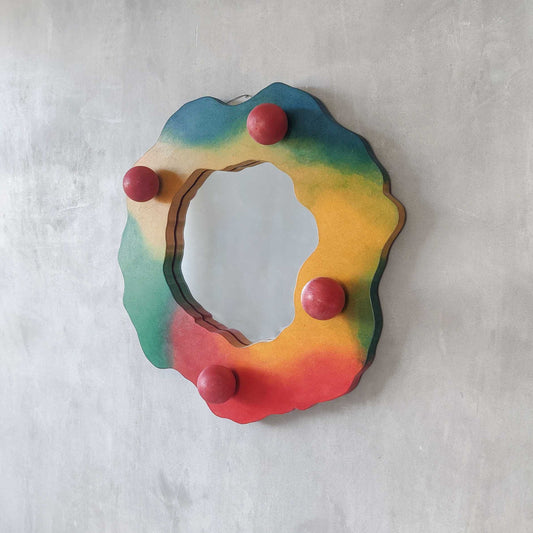 A 1980s sculptural studio craft airbrushed wavy mirror with spheres